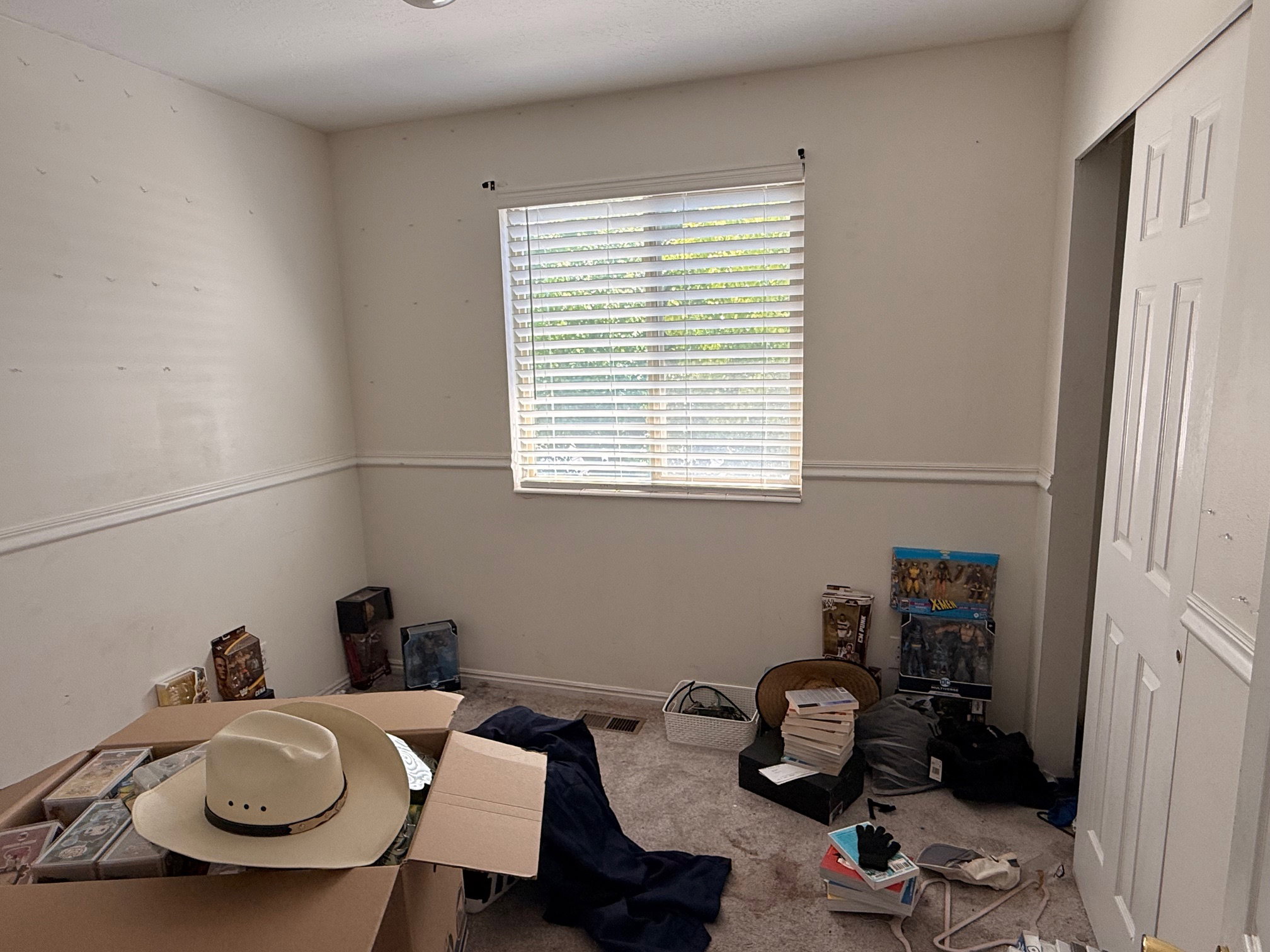 Room featuring neutral walls with chair rail molding, a window with horizontal blinds, and recessed ceiling lighting
