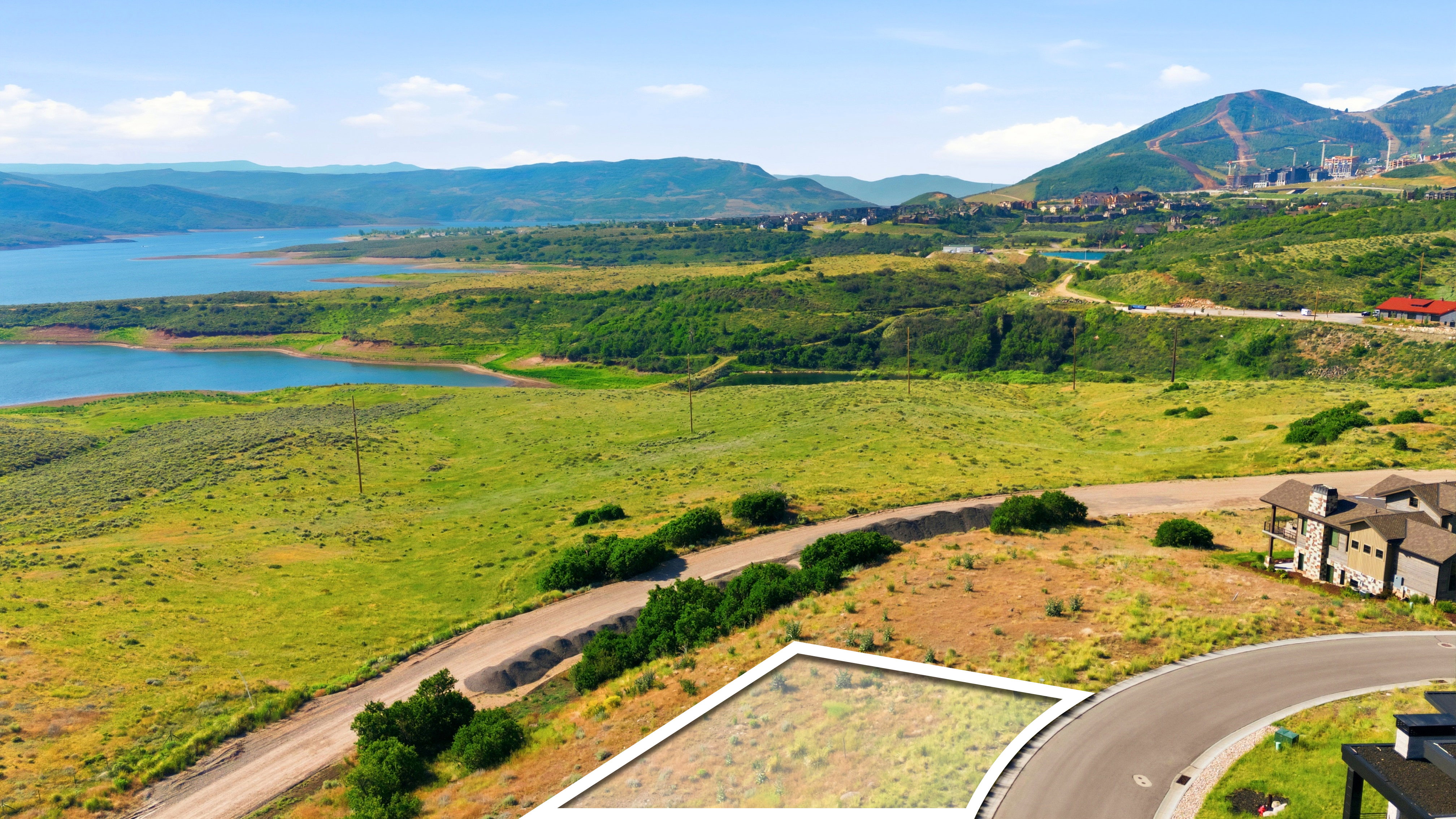 Expansive lot featuring a cul-de-sac location, paved road frontage, natural landscaping, and sweeping water and mountain terrain