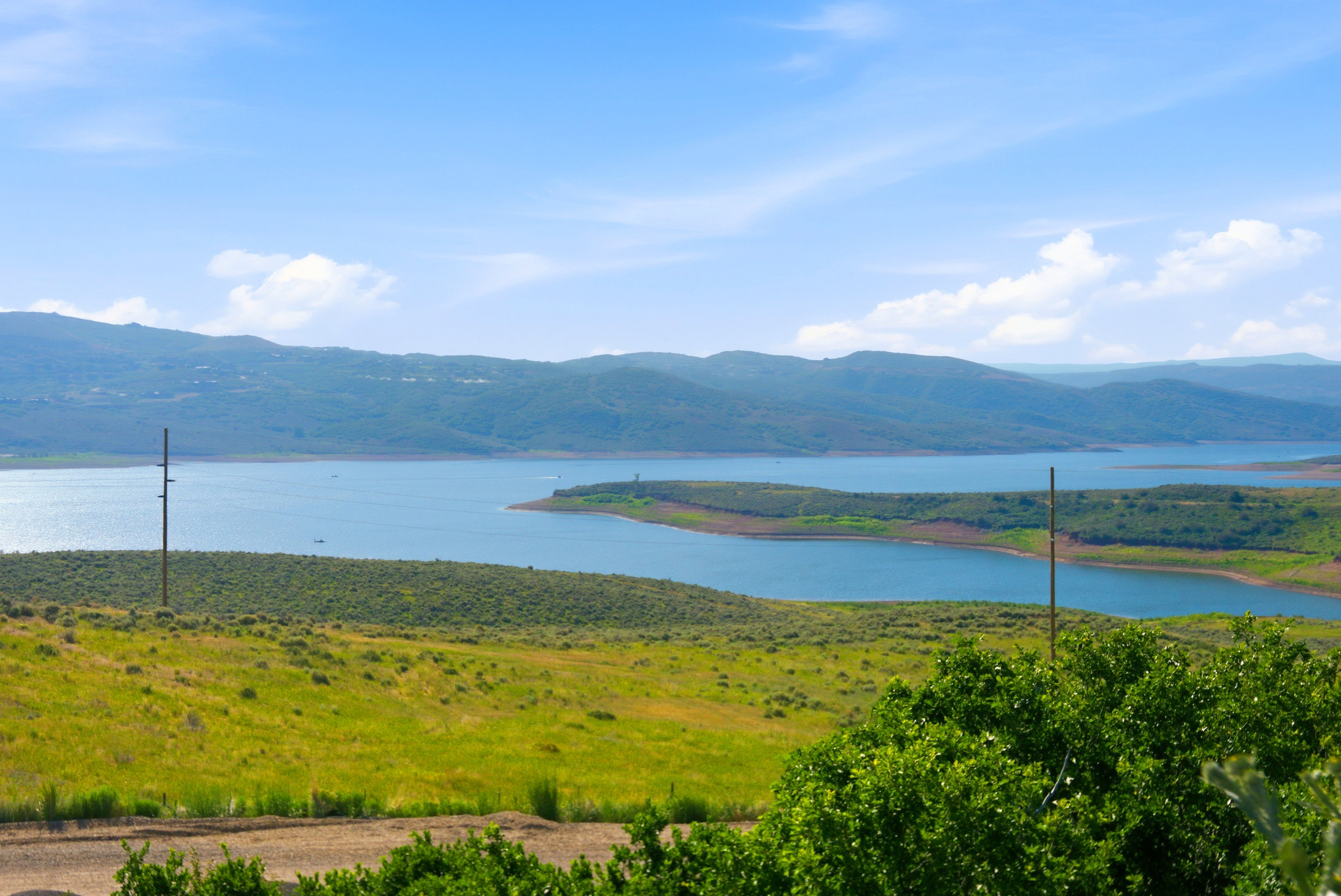 Expansive natural landscape with a large body of water surrounded by rolling hills and distant mountains
