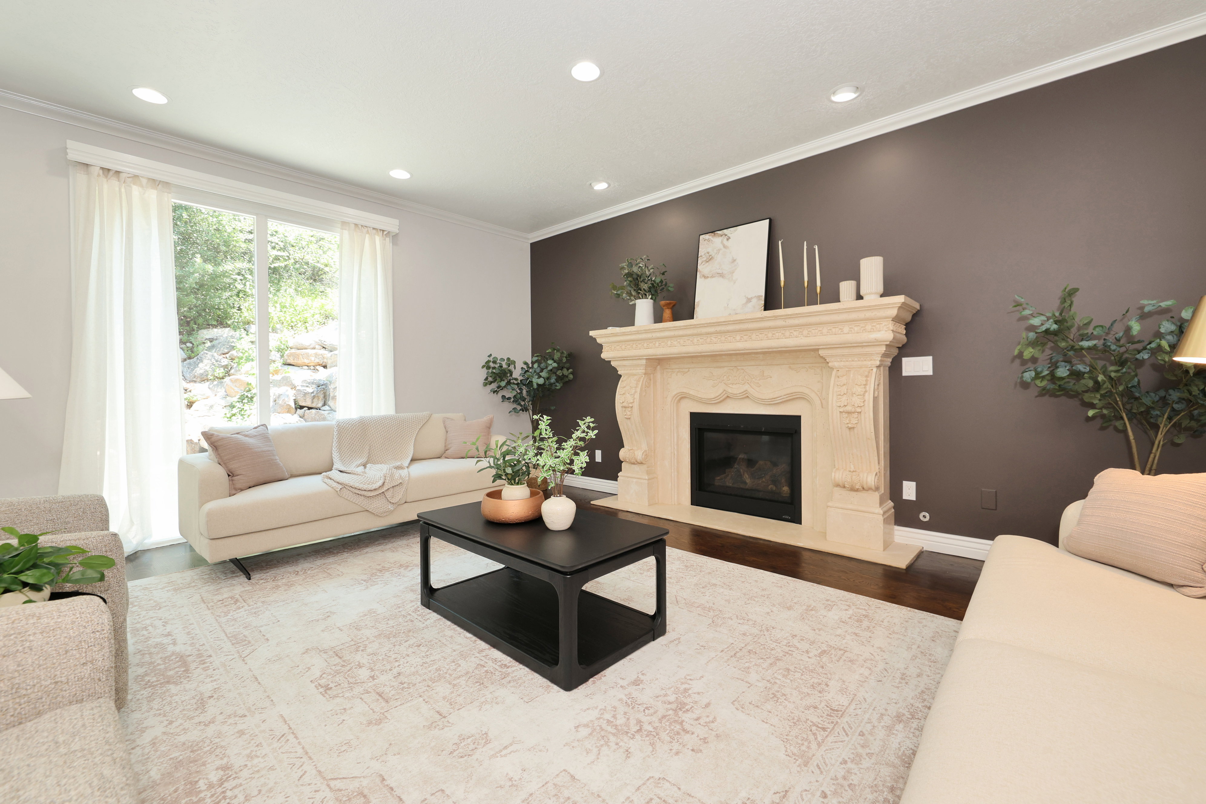 Ornate stone fireplace with a dark-tiled firebox, set against an accent wall