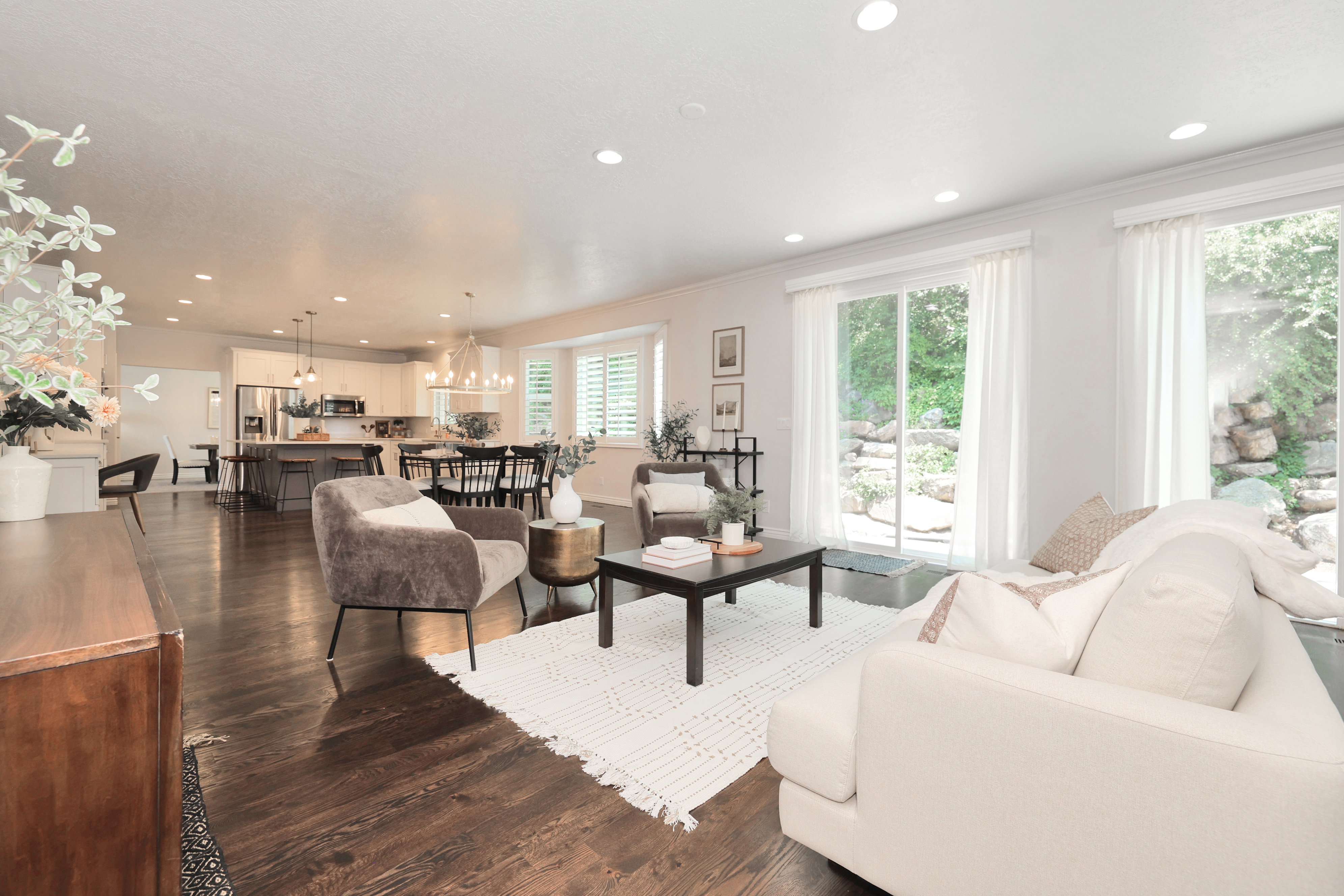 Open-concept living area with dark wood-finish flooring, recessed lighting, and multiple sliding glass doors