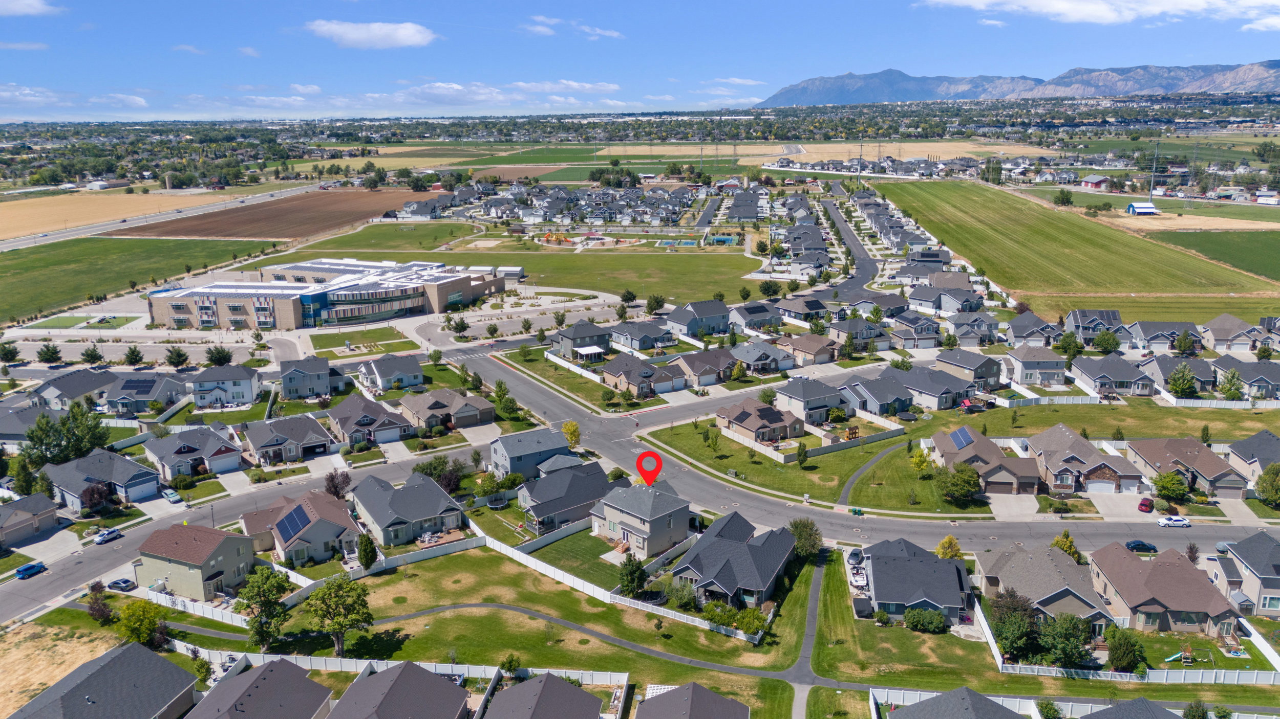 Residential development featuring single-family homes with mountain backdrops and agricultural fields