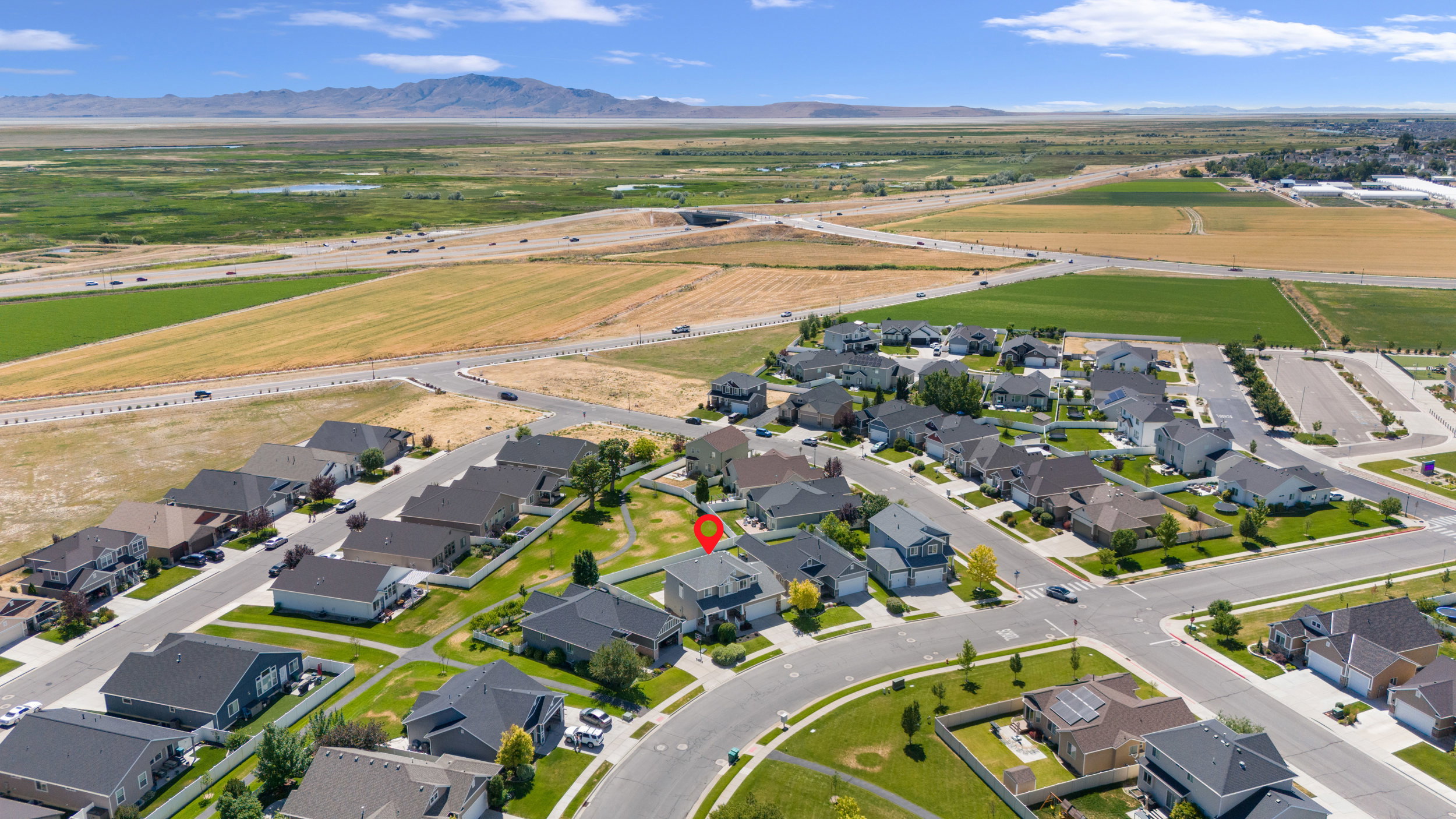 Aerial perspective showcasing a residential neighborhood with varied home styles, manicured lawns, and paved streets
