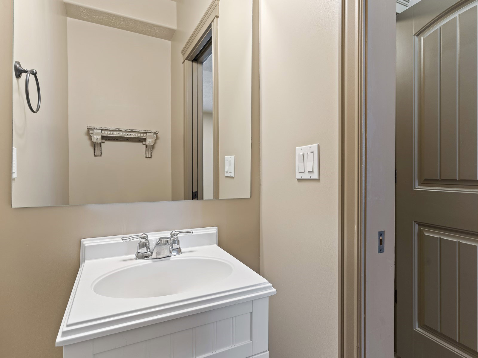 White vanity with integrated sink, chrome faucet, and rectangular mirror