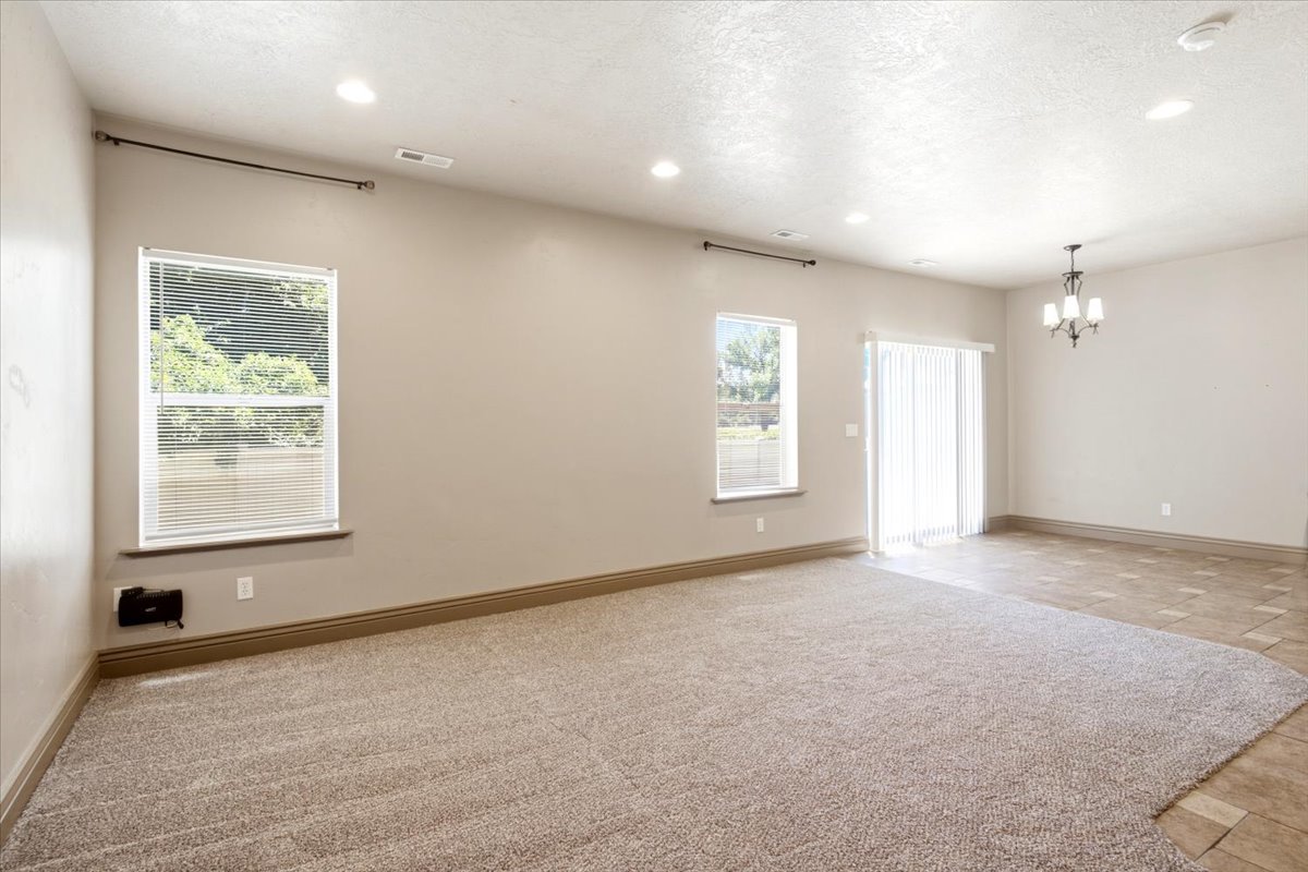 Spacious interior featuring neutral carpeting and a distinct tile area