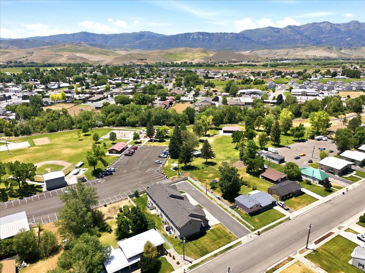 Expansive community featuring residential properties, mature trees, and a mountain backdrop