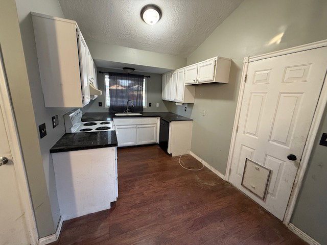 Kitchen featuring white cabinetry, dark countertops, a built-in sink, a window with horizontal blinds, and wood-finish flooring