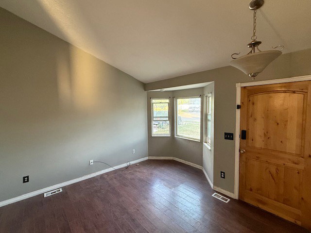 Entry area featuring wood-finish flooring, a natural wood door, and a bay window