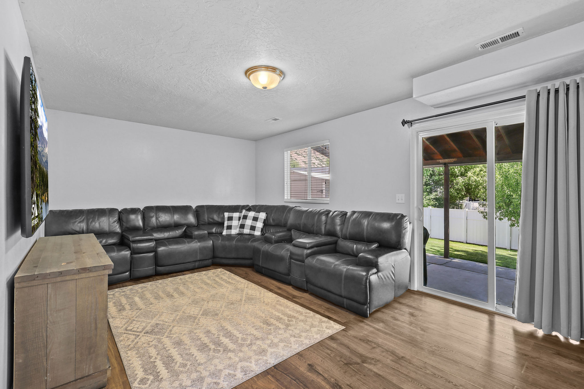 Wood-finish flooring throughout the room, complemented by a ceiling-mounted light fixture