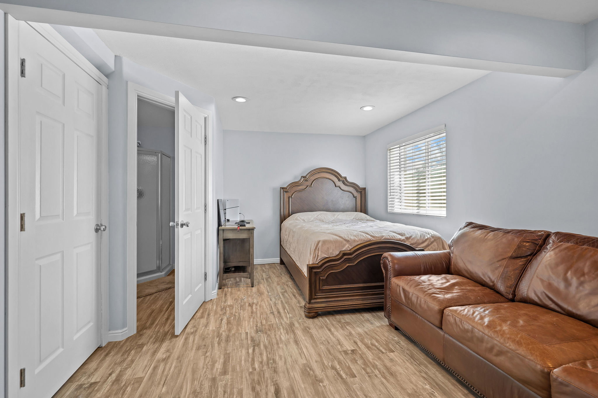 Bedroom featuring wood-finish flooring, recessed lighting, and a window with blinds