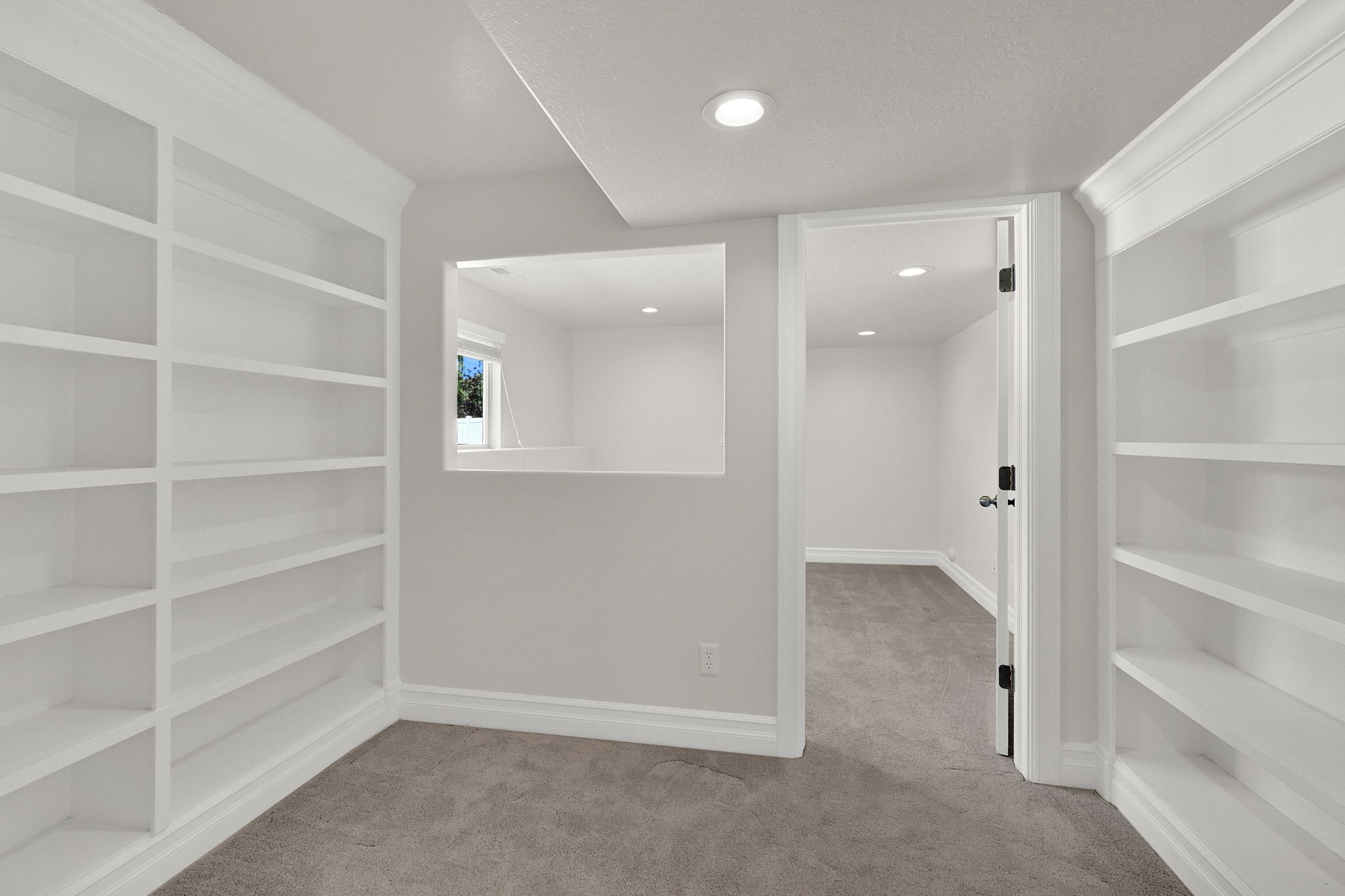 Bedroom featuring extensive built-in shelving, recessed lighting, and a neutral carpeted floor
