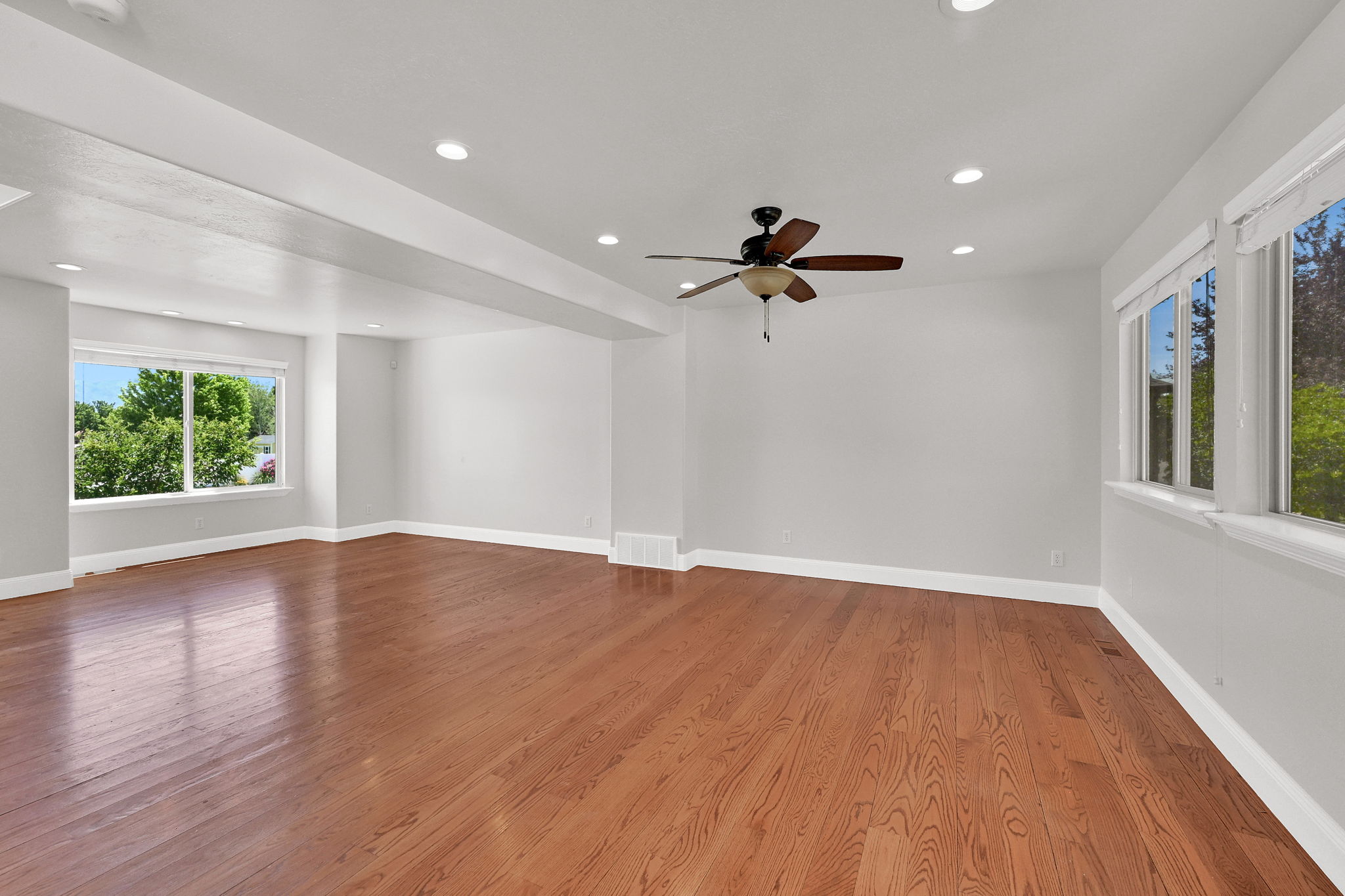 Spacious interior featuring wood-finish flooring, recessed lighting, and multiple windows