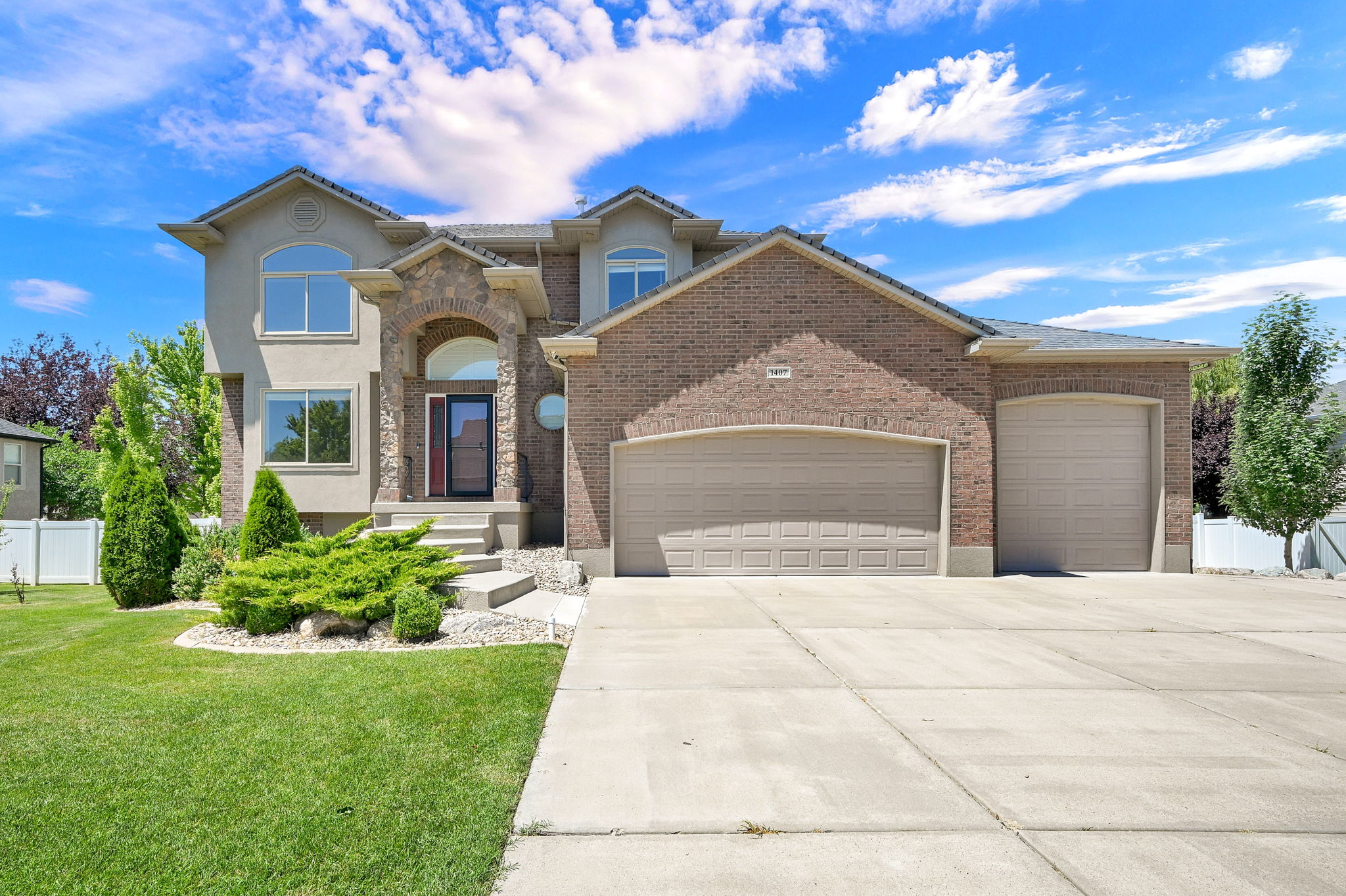 Stucco and brick exterior with stone accents and arched entry