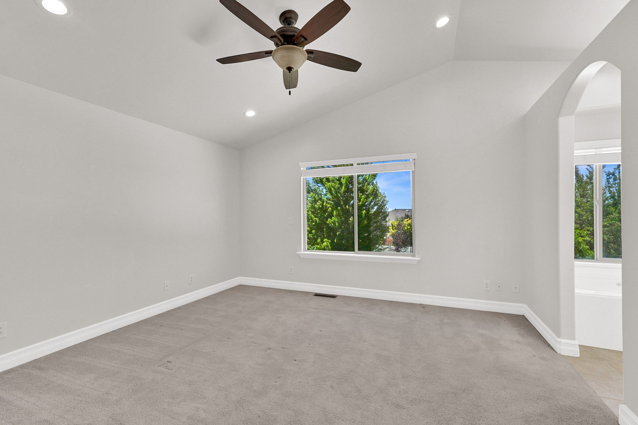 Spacious room with vaulted ceilings and recessed lighting