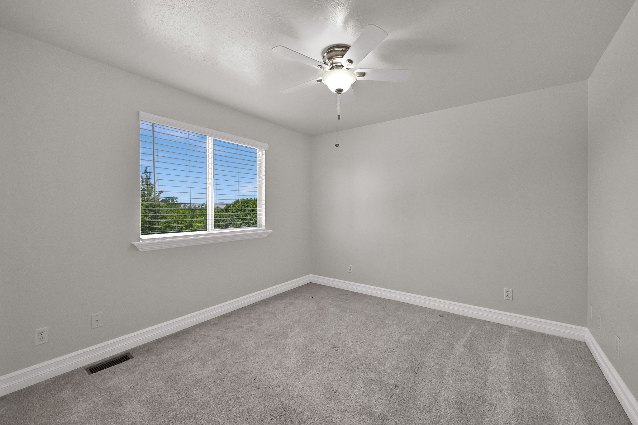 Carpeted interior space with a window featuring horizontal blinds