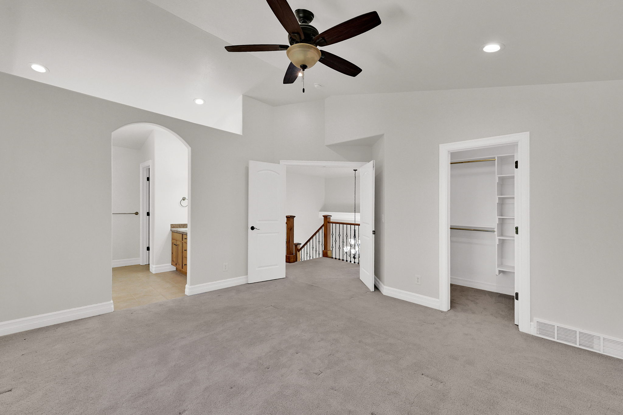 Carpeted room with a vaulted ceiling, recessed lighting, and a ceiling fan