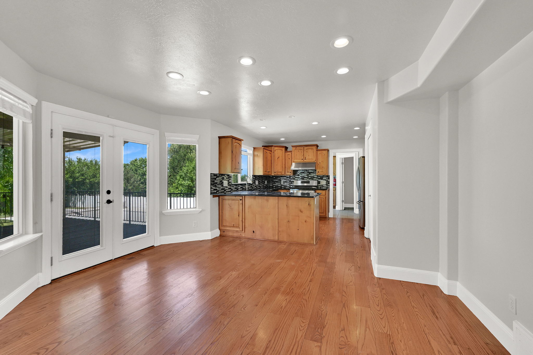 Hardwood-style flooring throughout the main living area, featuring light gray wall paint and recessed lighting
