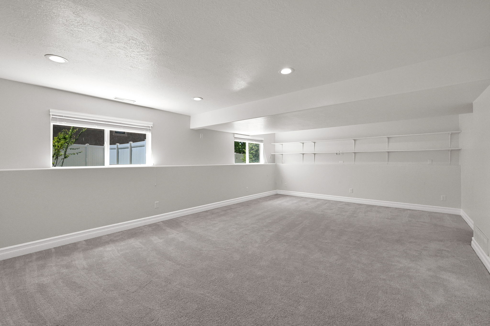 Spacious room featuring neutral carpeting and light gray walls