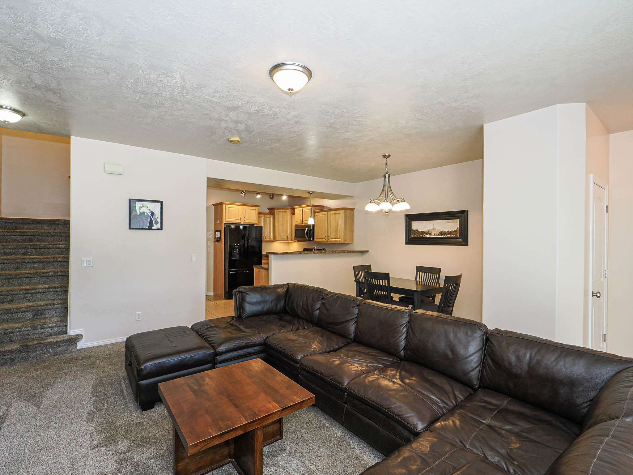 Open-concept living area with textured ceilings and overhead lighting
