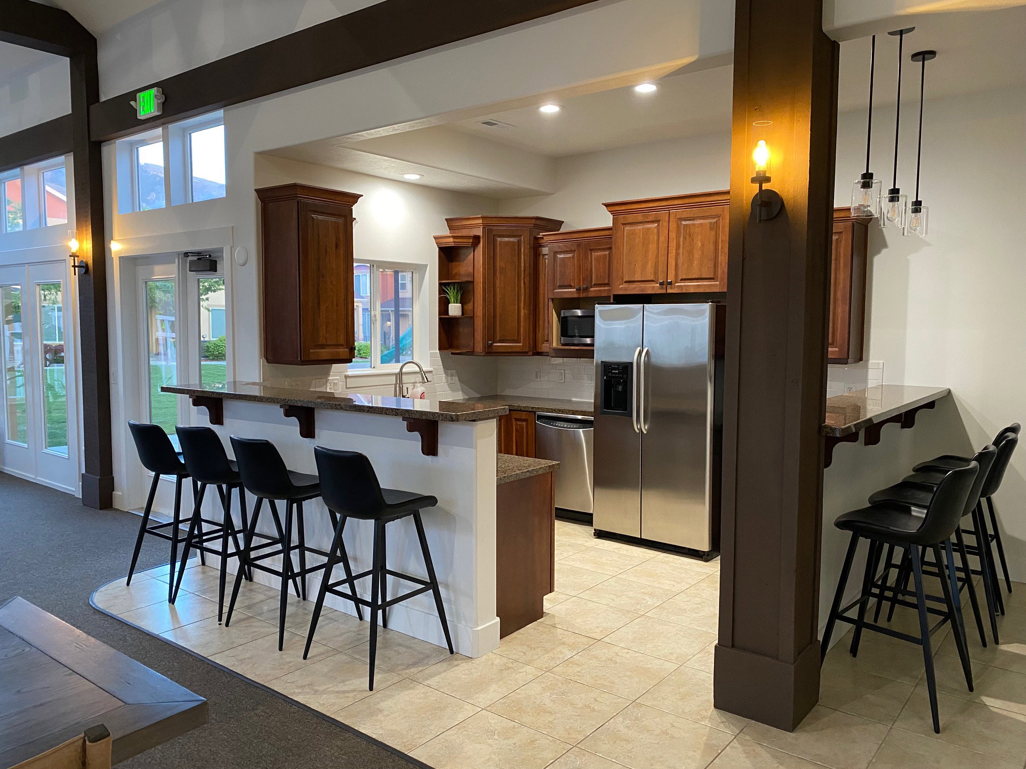 Full kitchen featuring wood cabinetry, stainless steel appliances, and a breakfast bar with stone countertops