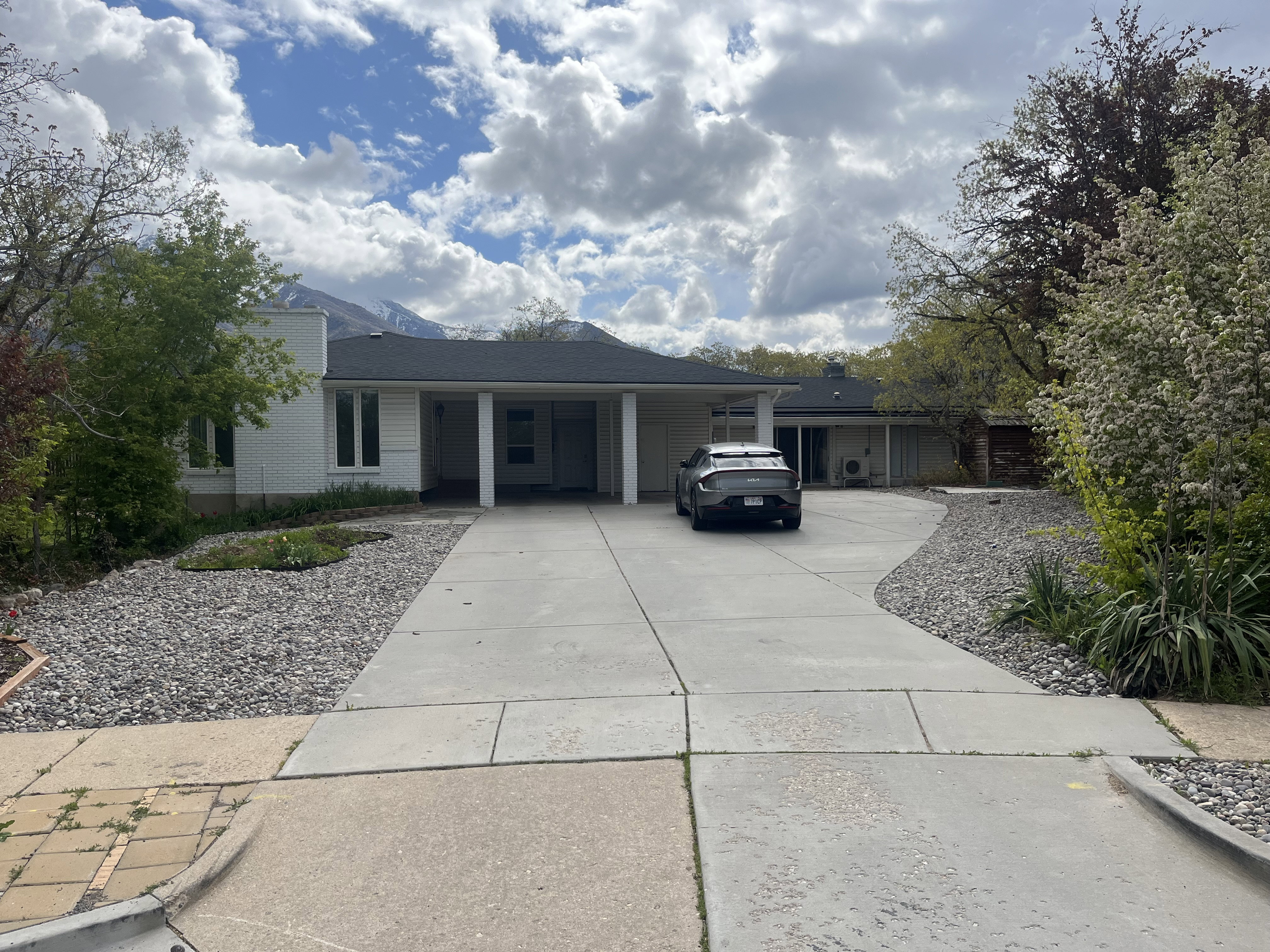 Ranch-style residence featuring a prominent portico and a curved concrete driveway