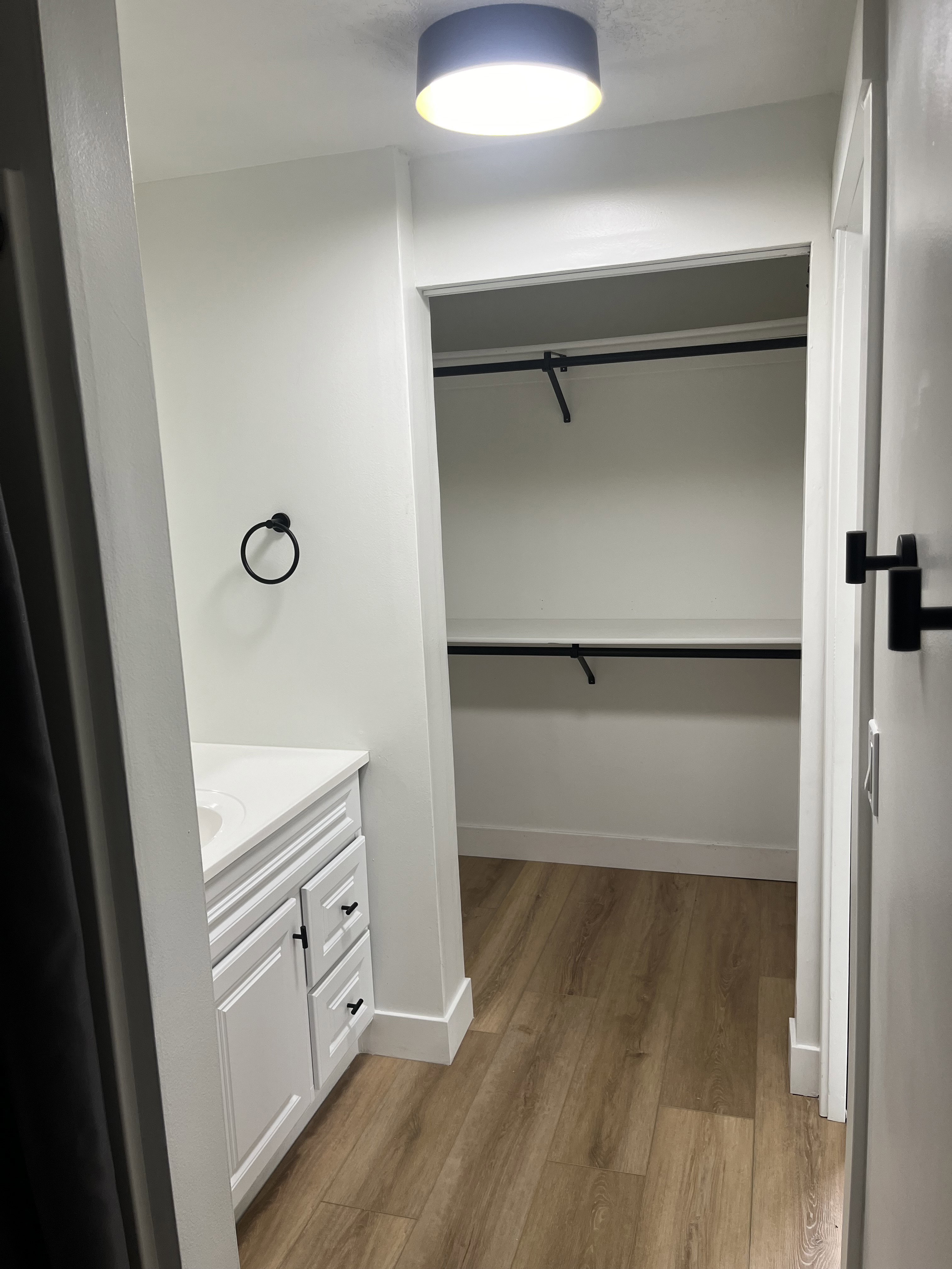 Vanity area with a white shaker-style cabinet, a white countertop, and a round undermount sink