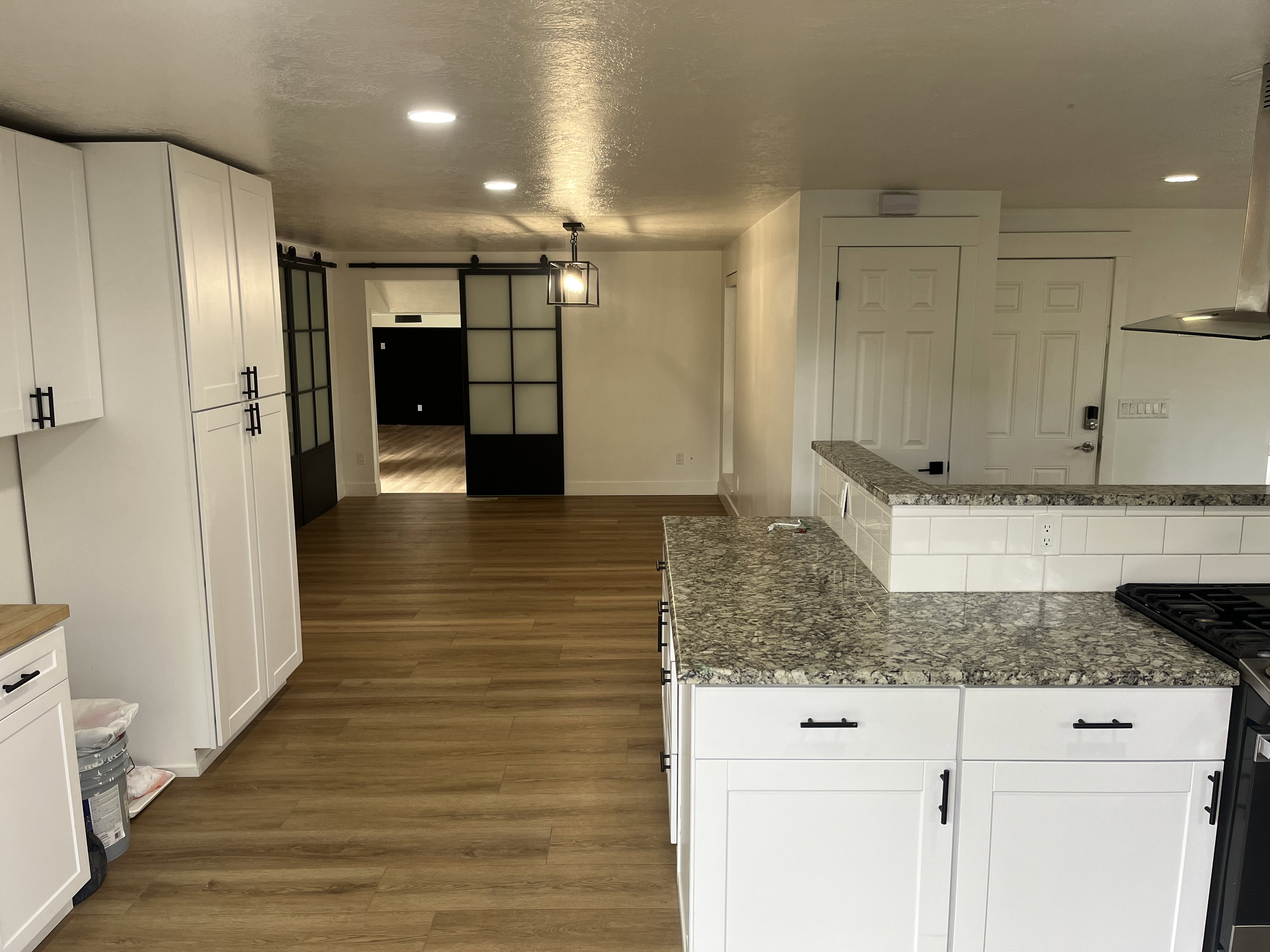 Kitchen featuring white cabinetry, granite countertops, and wood-finish flooring
