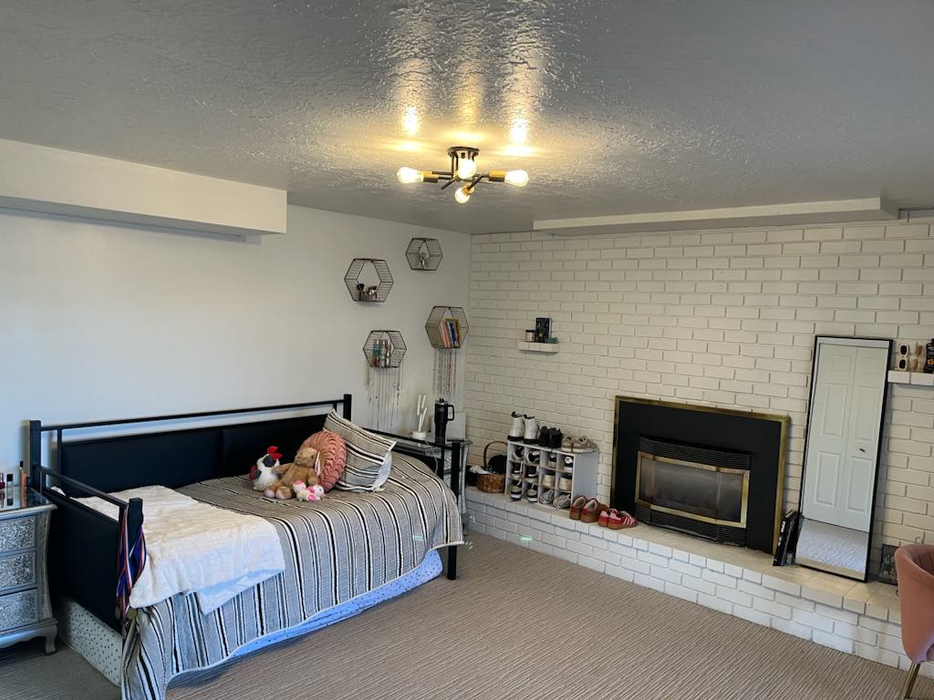 White-painted brick fireplace with a black and brass insert