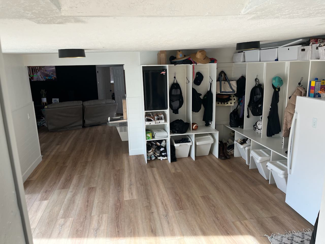 Mudroom with wood-finish flooring featuring extensive built-in storage cubbies, individual shelving compartments, and coat hooks
