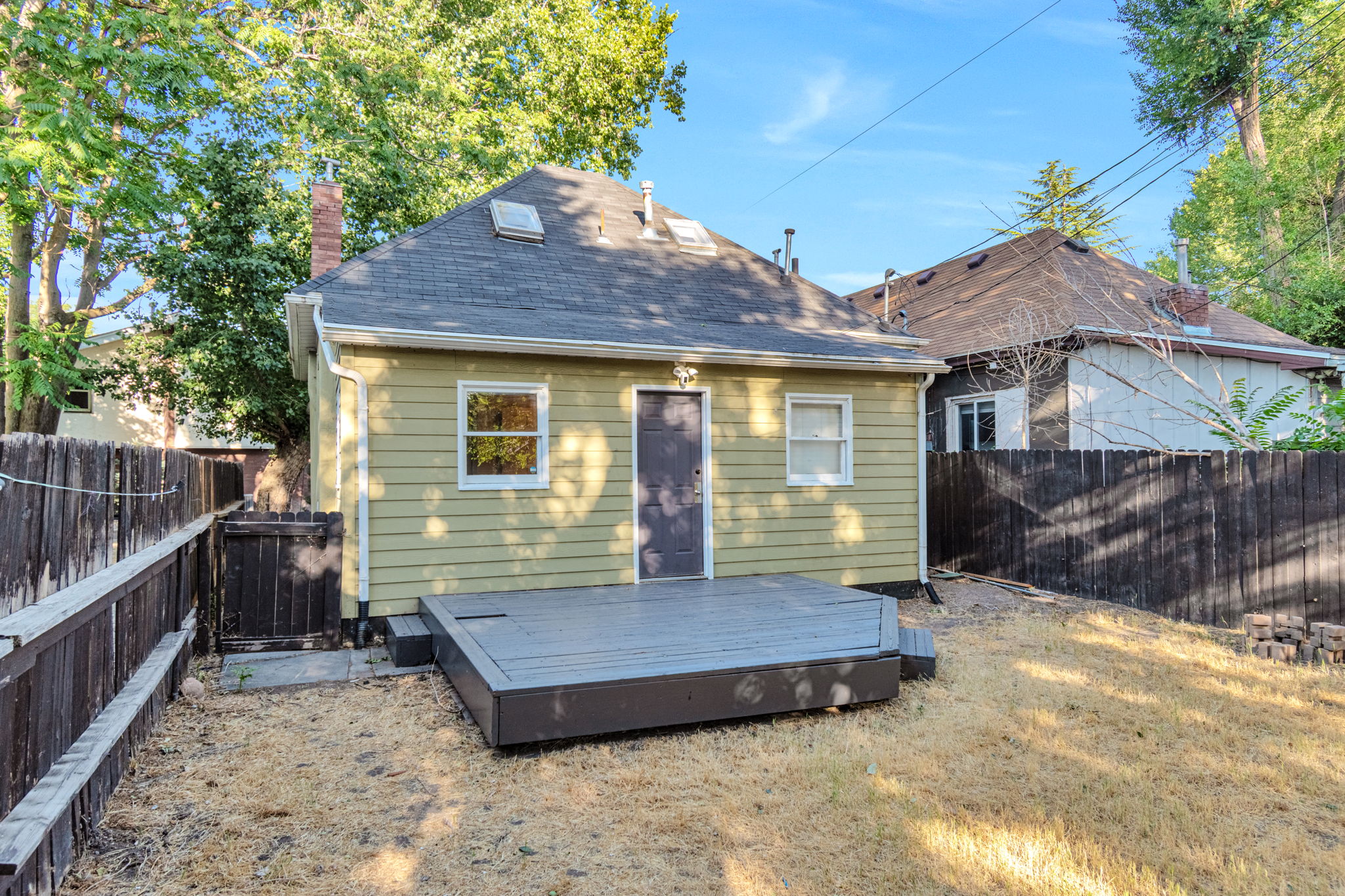 Rear exterior featuring a deck with steps, horizontal siding, and a gabled roof