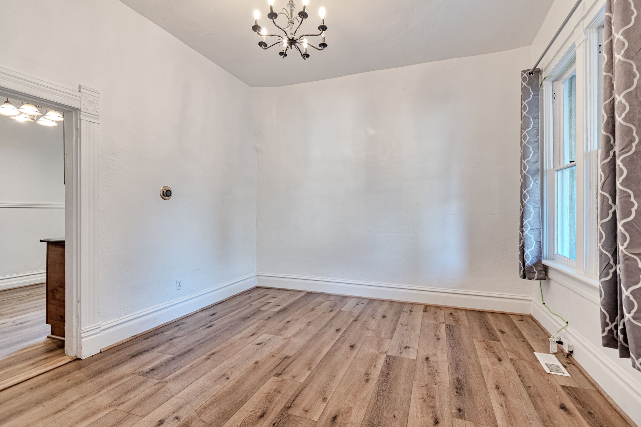 Laminate Flooring, tall ceilings, and a chandelier.