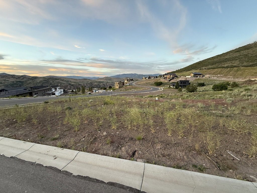 Expansive land parcel featuring existing hillside development and paved roads