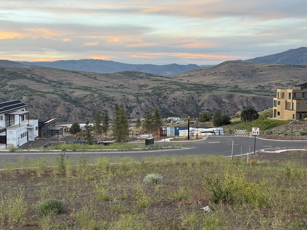 Expansive mountain backdrop with a visible road structure and varying architectural styles
