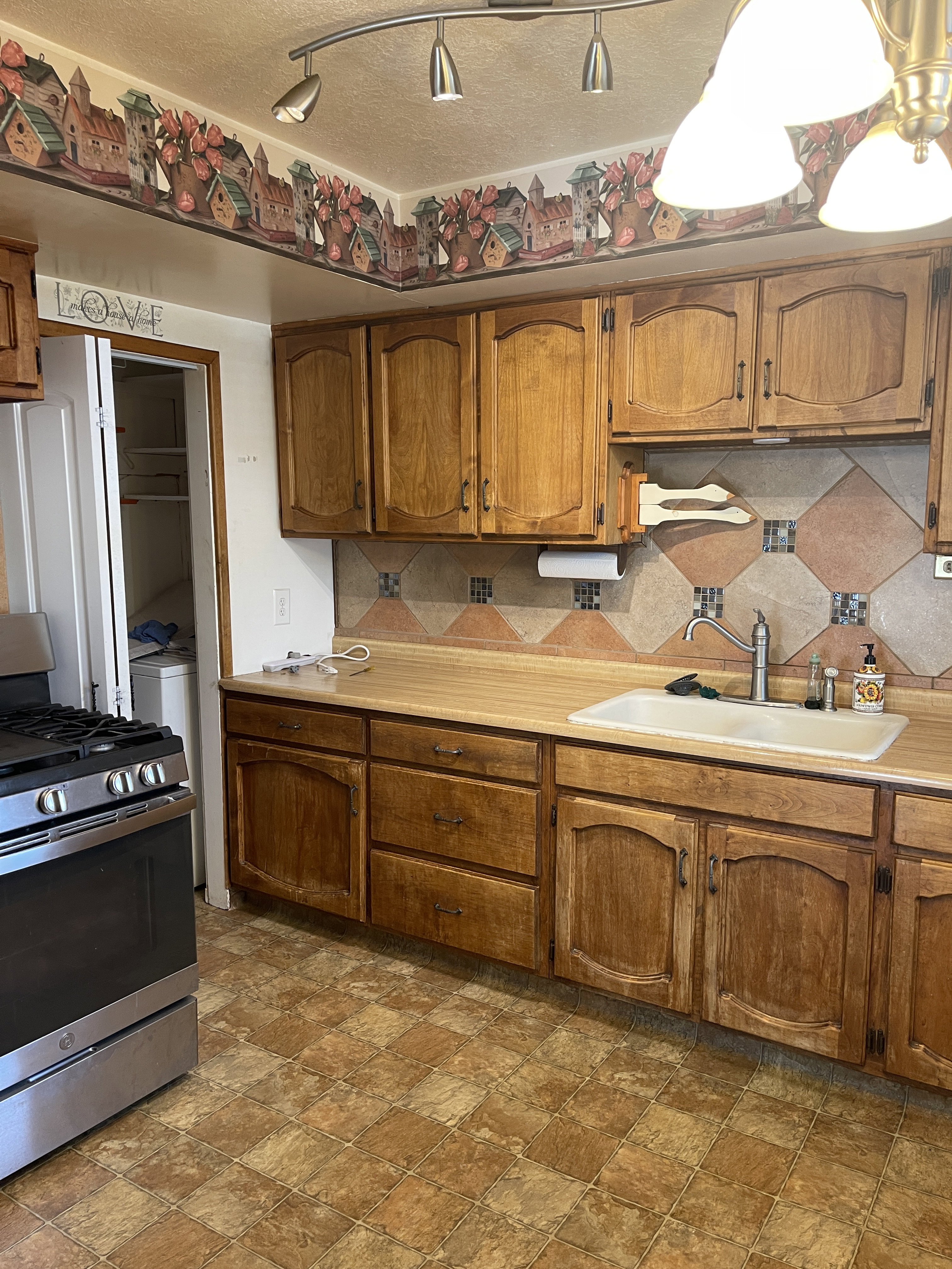 Kitchen featuring wood cabinetry, laminate countertops, a tile backsplash, and checkered floor tiles