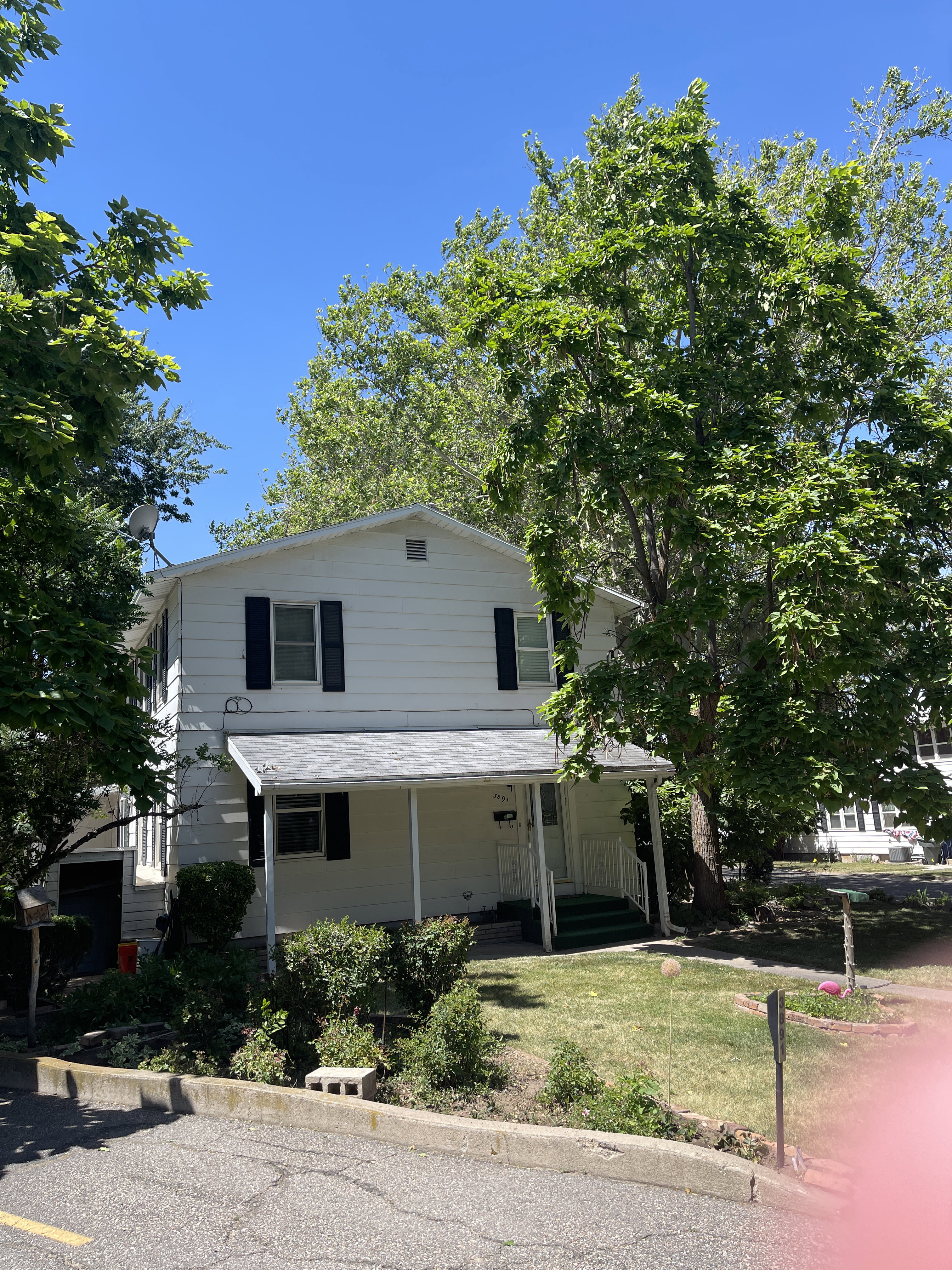Two-story residence with white siding and black window shutters