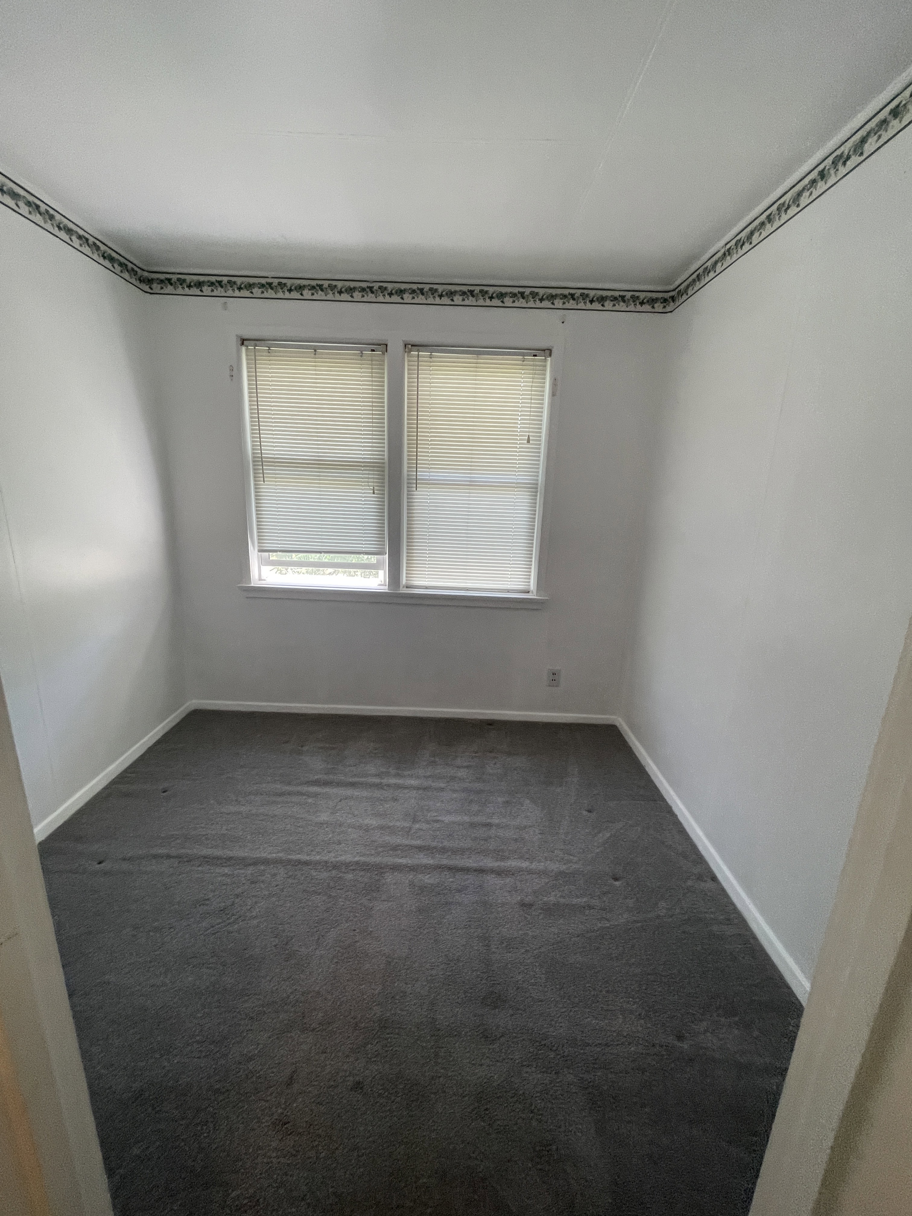 Interior room featuring dual windows with horizontal blinds, providing natural illumination