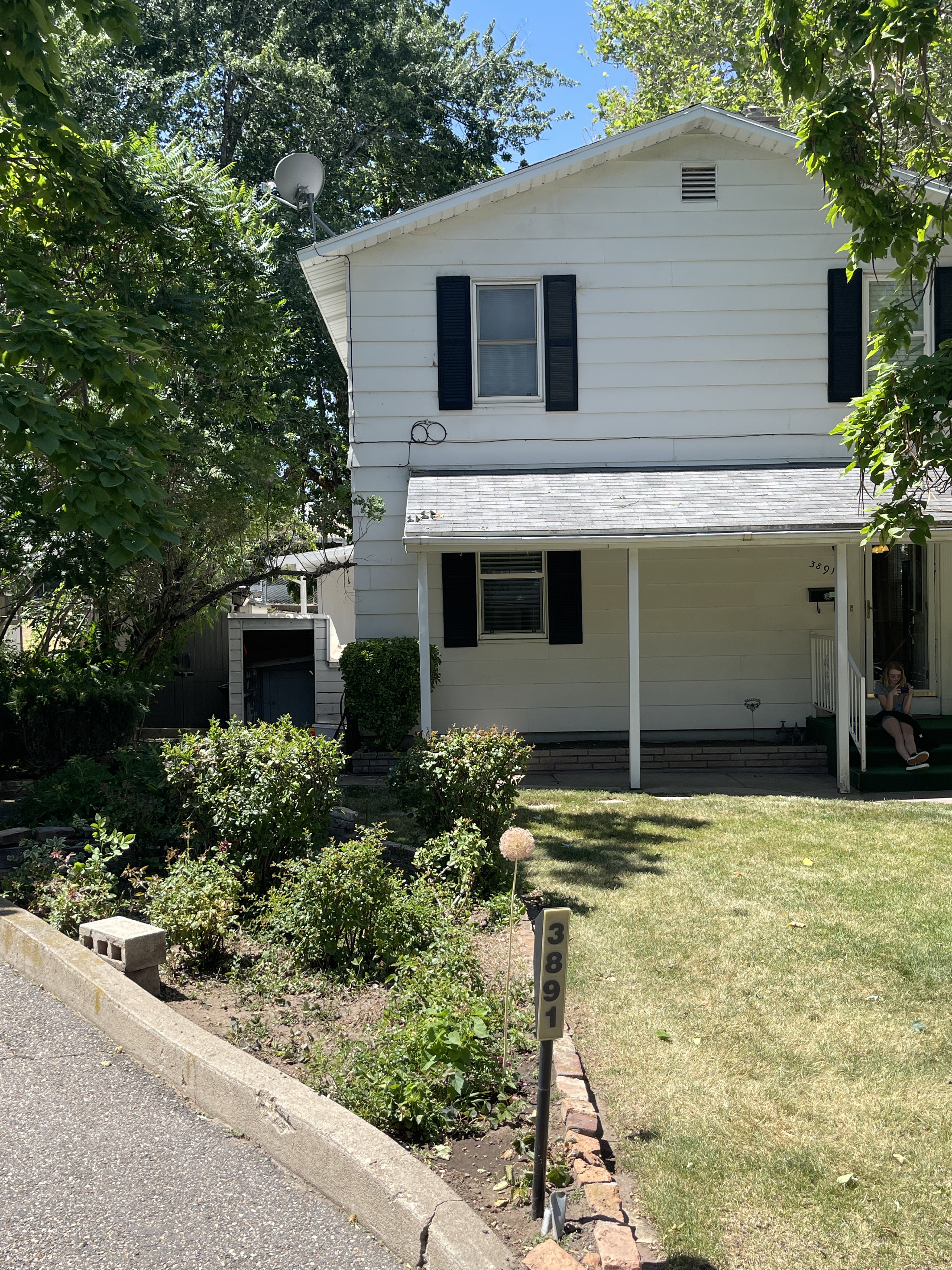 Two-story residence featuring white siding and dark shutters
