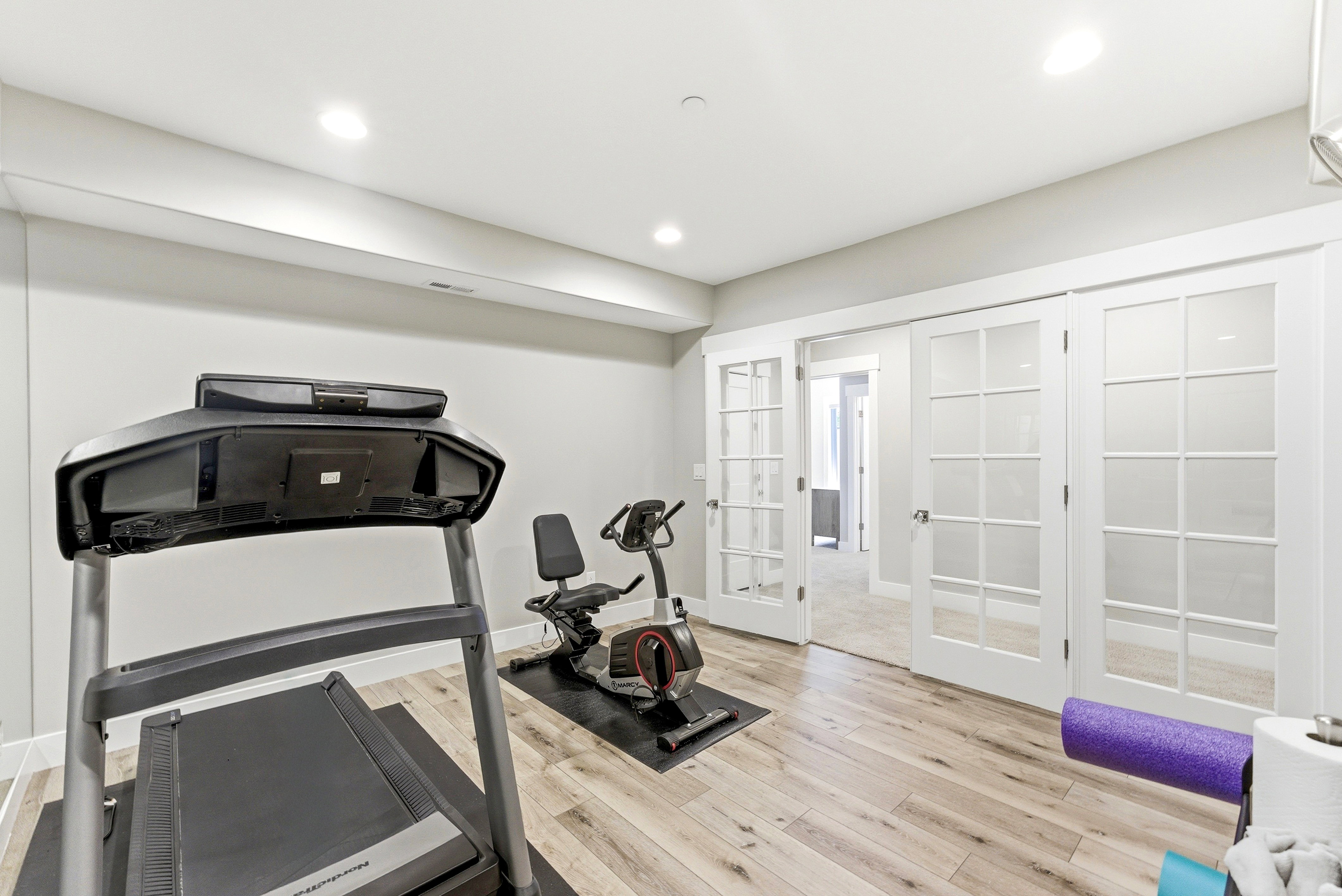 Room with wood-finish flooring, recessed lighting, and white trim