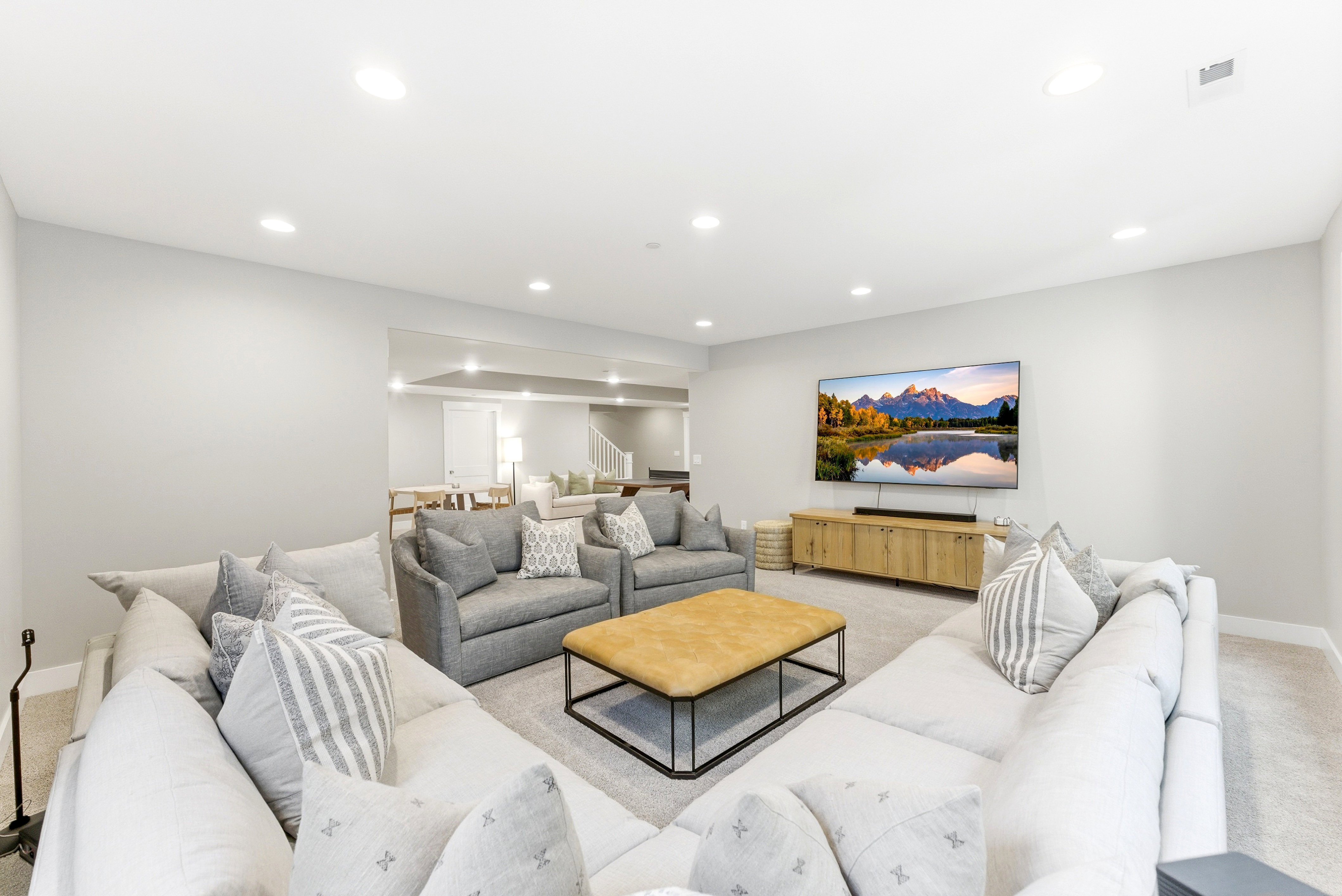 Spacious entertainment room featuring recessed lighting, light-toned carpeting, and an open layout to additional areas