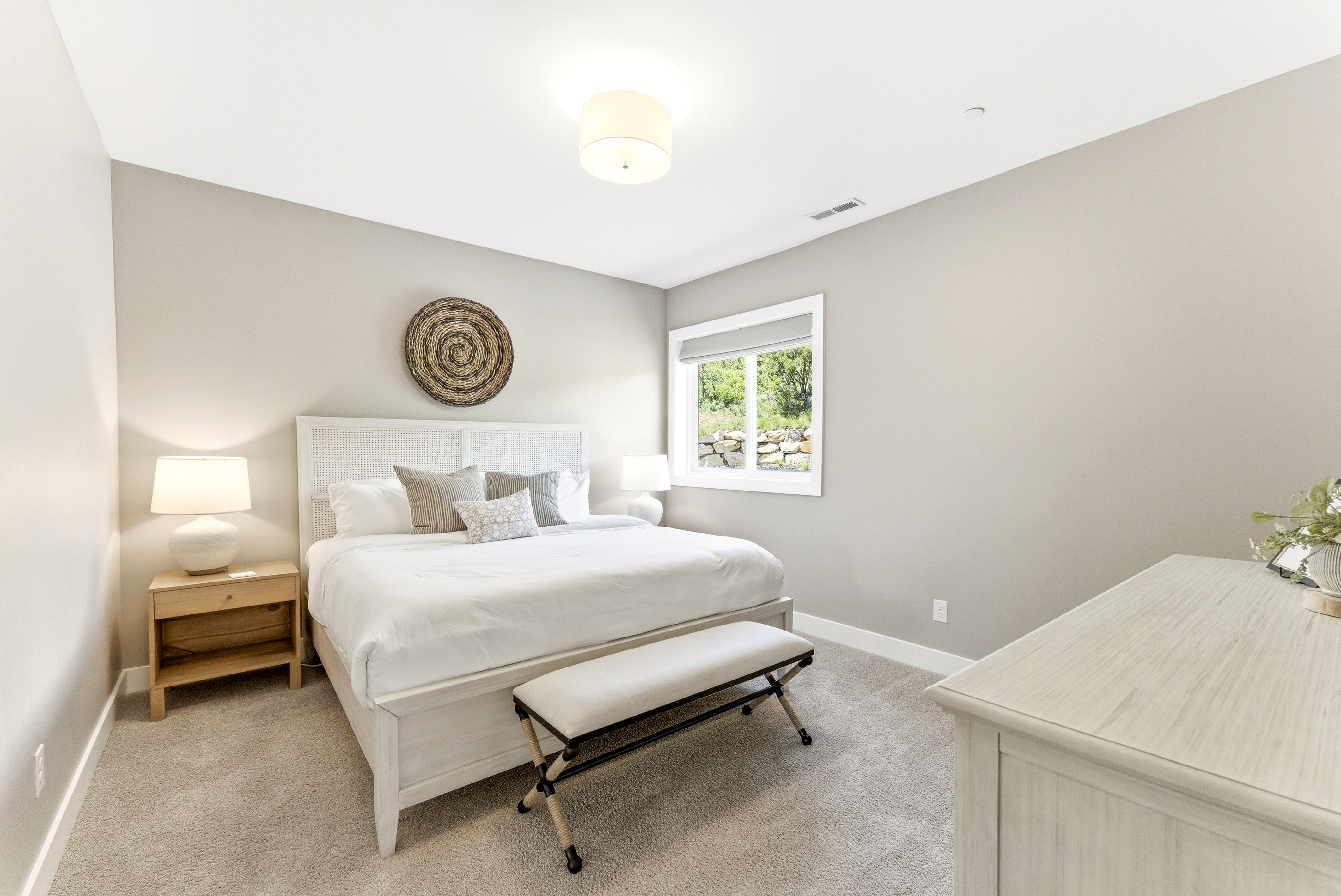 Carpeted room with a window featuring a roller shade, recessed lighting, and a drum ceiling light fixture