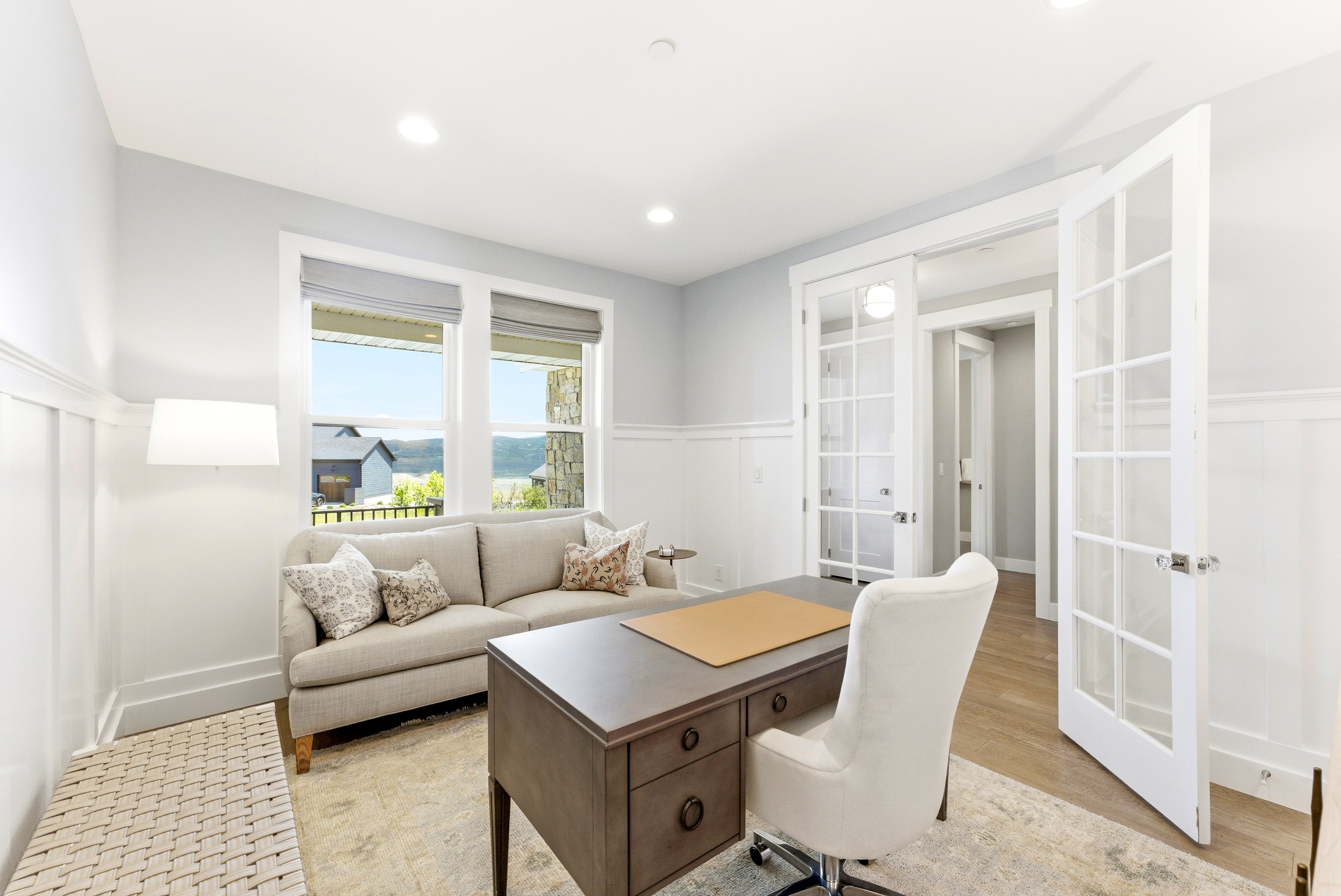 French doors with glass panels, recessed lighting, board and batten wall detailing, large windows with roller shades, and hardwood-finish flooring