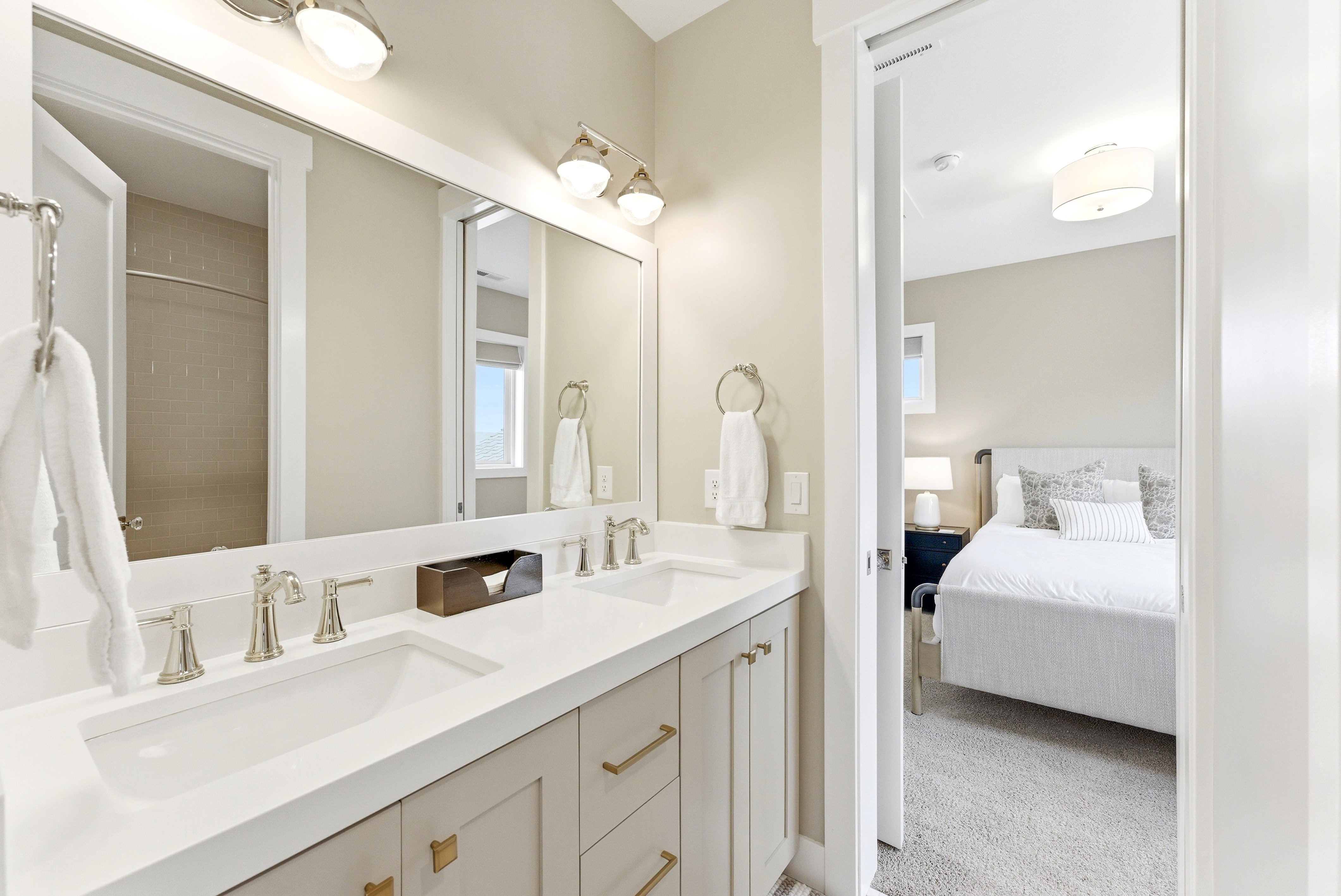 Bathroom vanity with dual undermount sinks, brushed nickel fixtures, and a white countertop