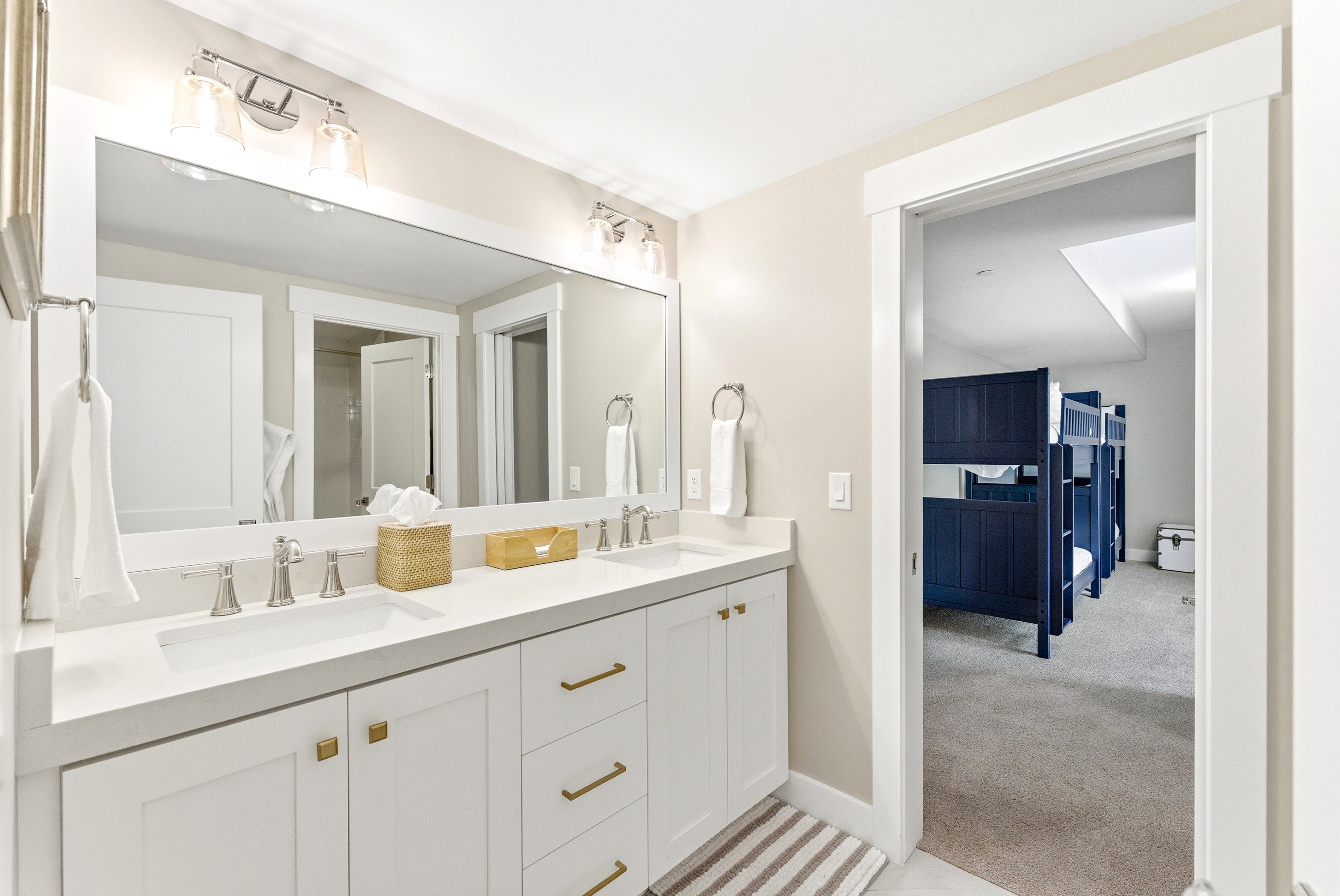 Double vanity featuring white cabinetry, light-colored countertops, and brushed nickel fixtures