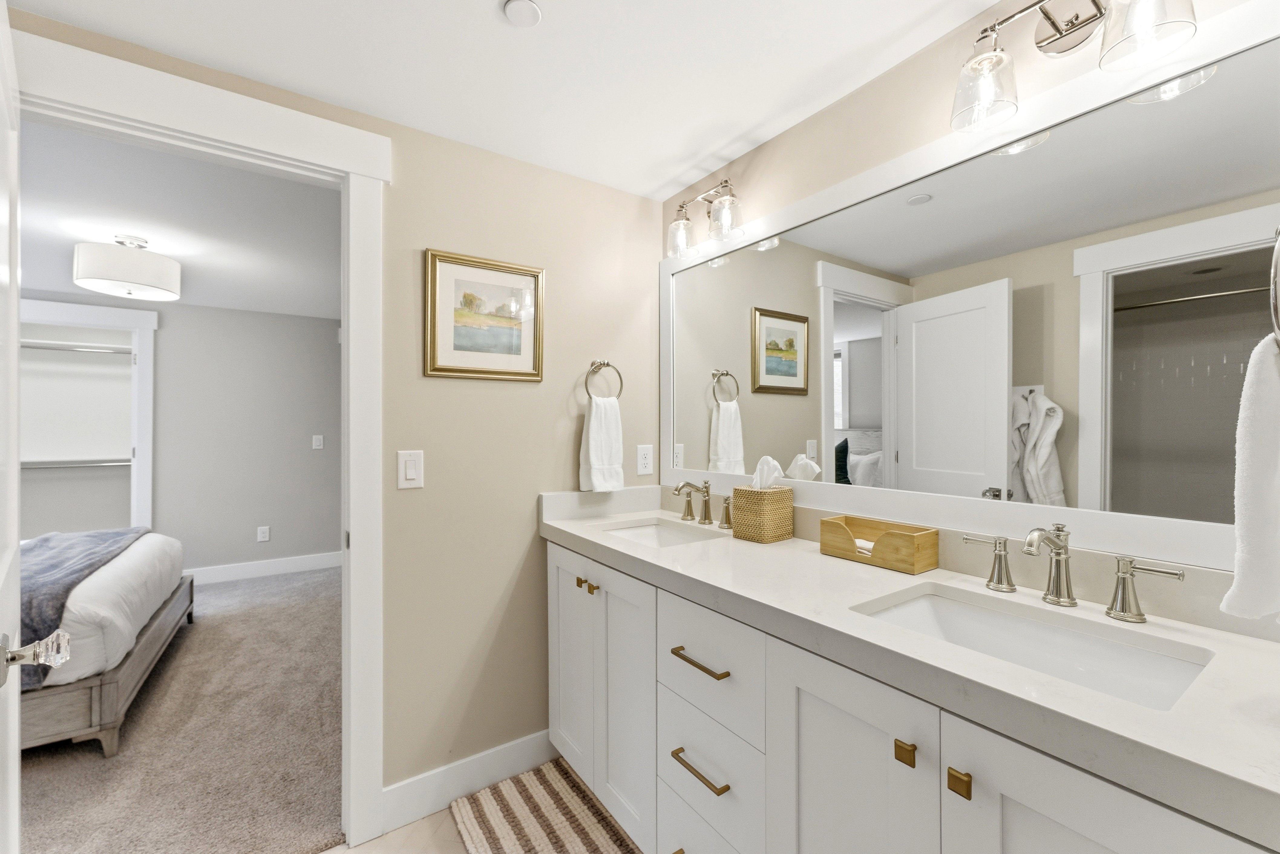 Dual vanity featuring white shaker cabinetry, brushed nickel hardware, and an expansive countertop