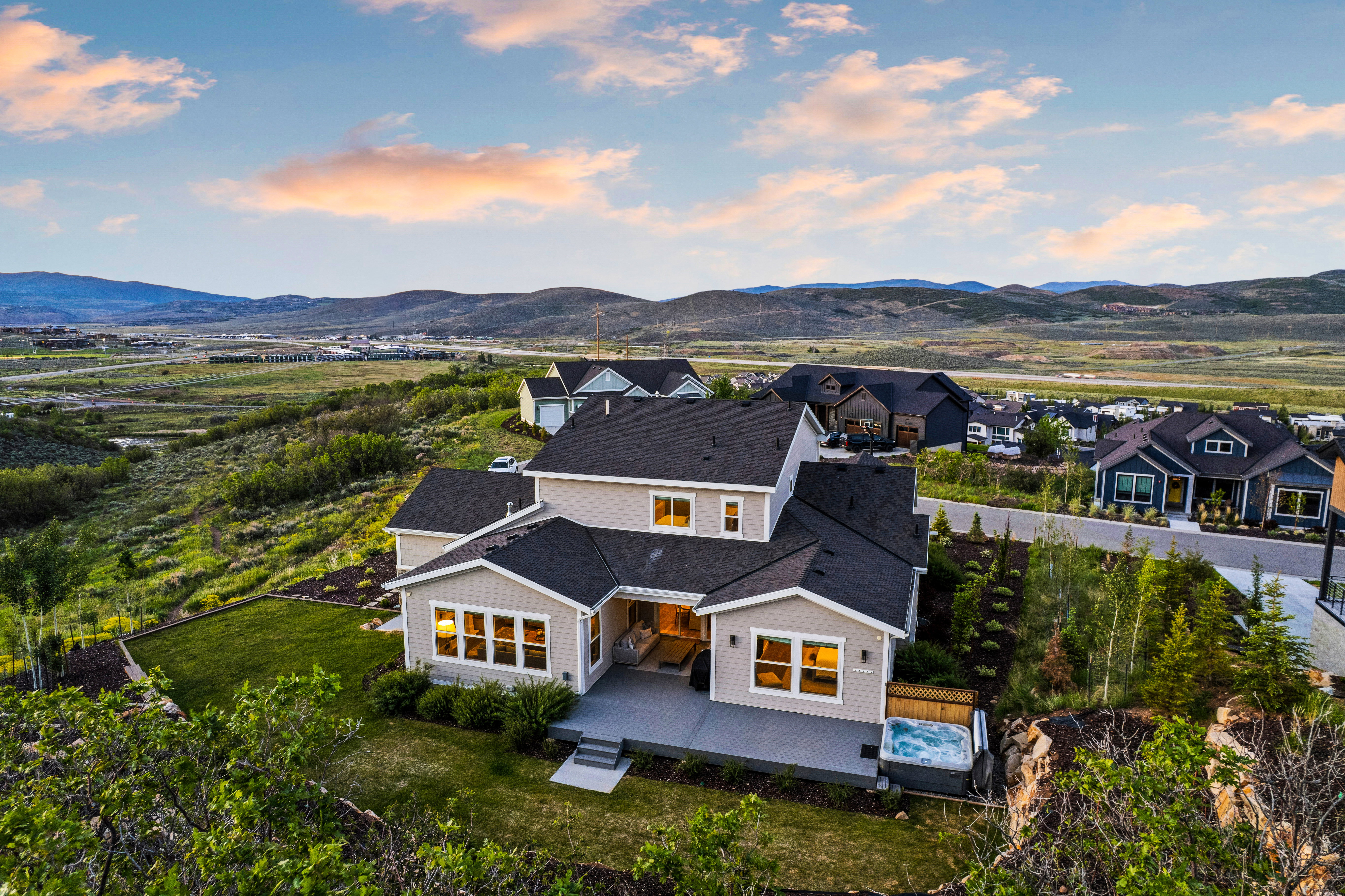 Contemporary residence featuring a spacious multi-level rear patio, integrated outdoor spa, and extensive landscaping