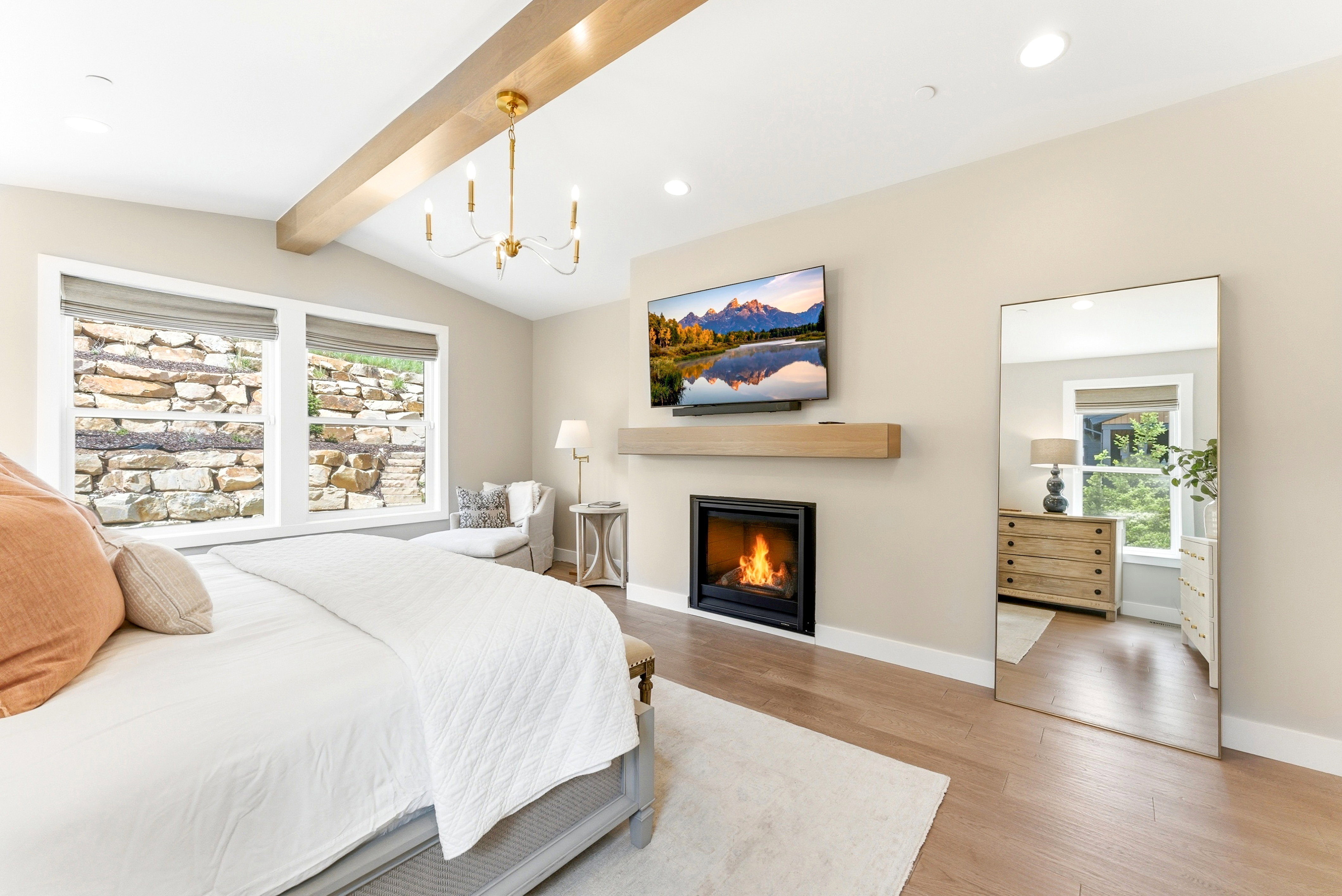 Vaulted ceiling featuring a light wood beam and a gold-finish chandelier