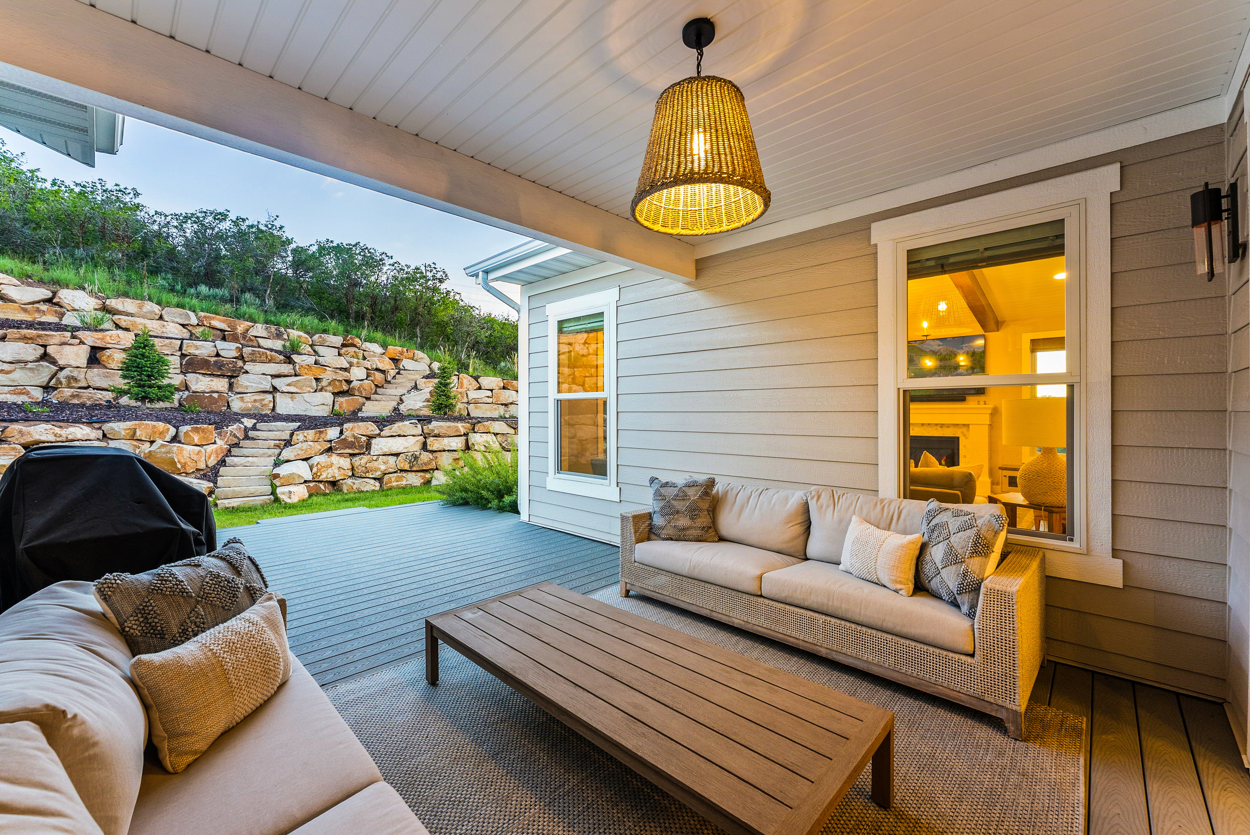 Covered patio featuring plank decking and a woven pendant light fixture
