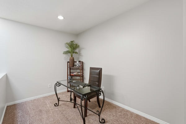 Carpeted room featuring light-colored walls, a recessed ceiling light, and white baseboards