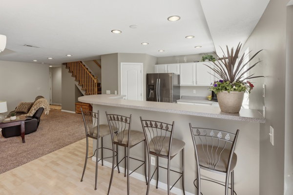 Kitchen peninsula with a light-toned countertop and integrated breakfast bar