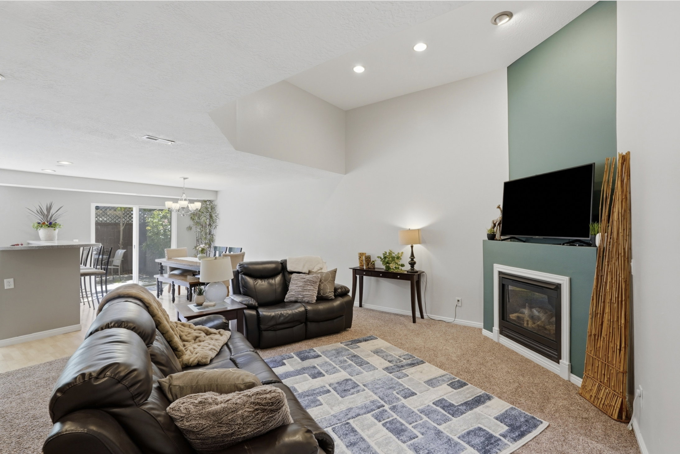 Spacious living area featuring a vaulted ceiling with recessed lighting